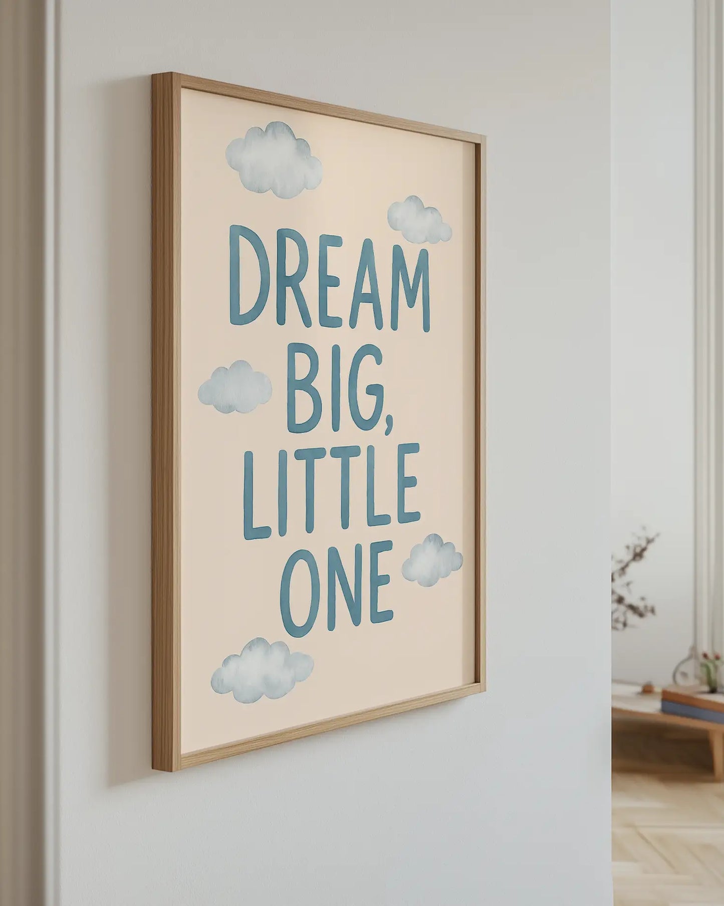 Inramad barntavla med texten “DREAM BIG, LITTLE ONE”, hängandes på väggen som en mjuk och inspirerande detalj i barnrummet.