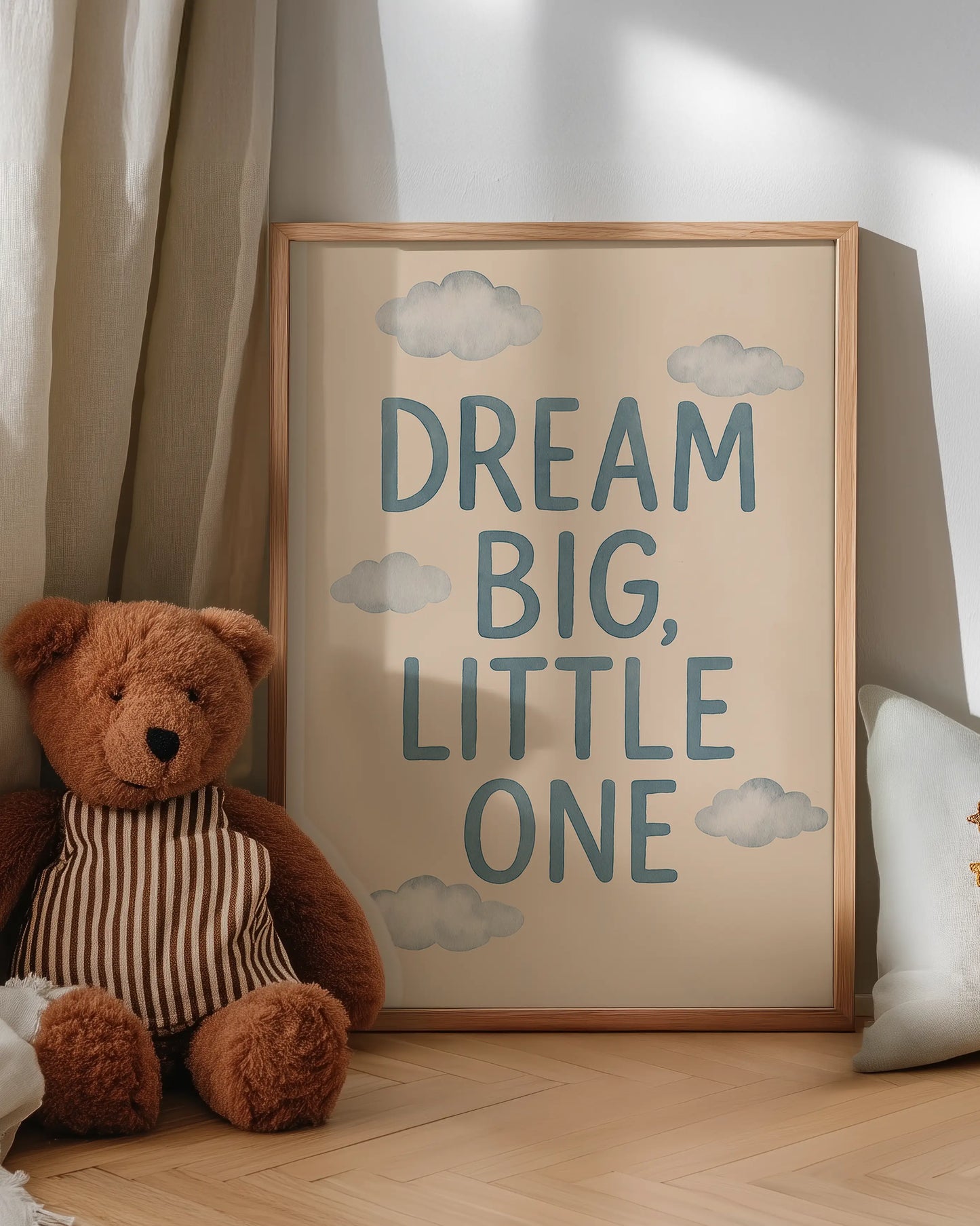 Barntavla med texten “DREAM BIG, LITTLE ONE”, lutad mot väggen bredvid en nalle och skapar en mysig och drömmig känsla.