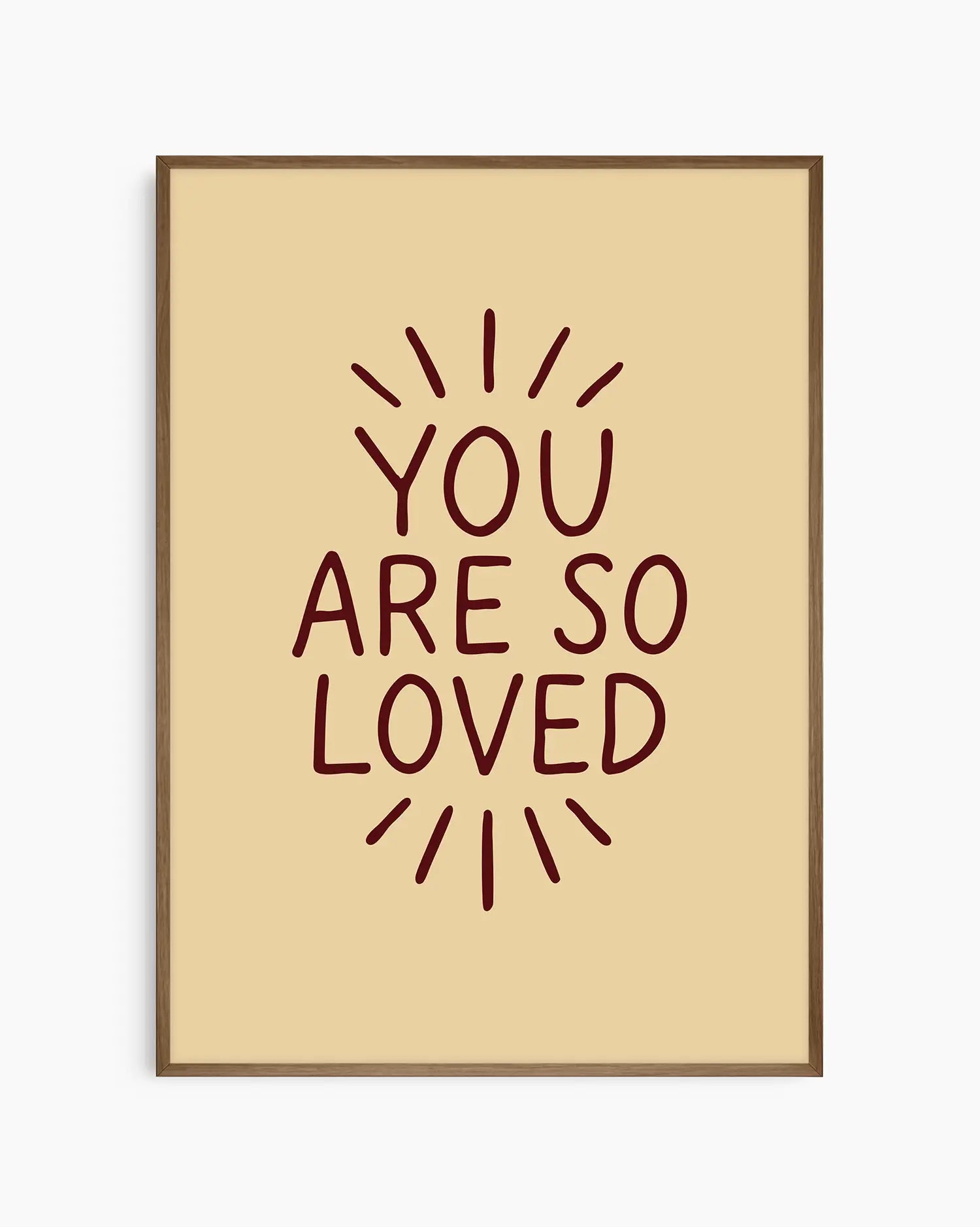 Barnrumstavla med ”YOU ARE SO LOVED” i mörkröd text på beige bakgrund, inramad i mörk ekram. En mjuk och stilfull detalj som skapar en ombonad känsla.