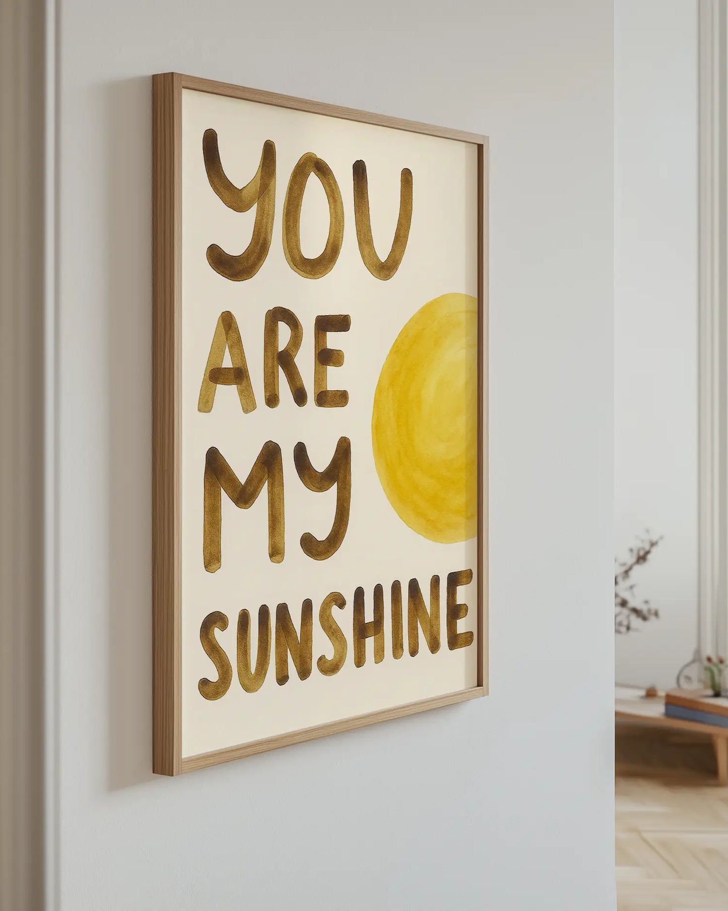 Barnrumstavla med "YOU ARE MY SUNSHINE" upphängd på vägg i ekram. En stilren och solig detalj som tillför värme och glädje.