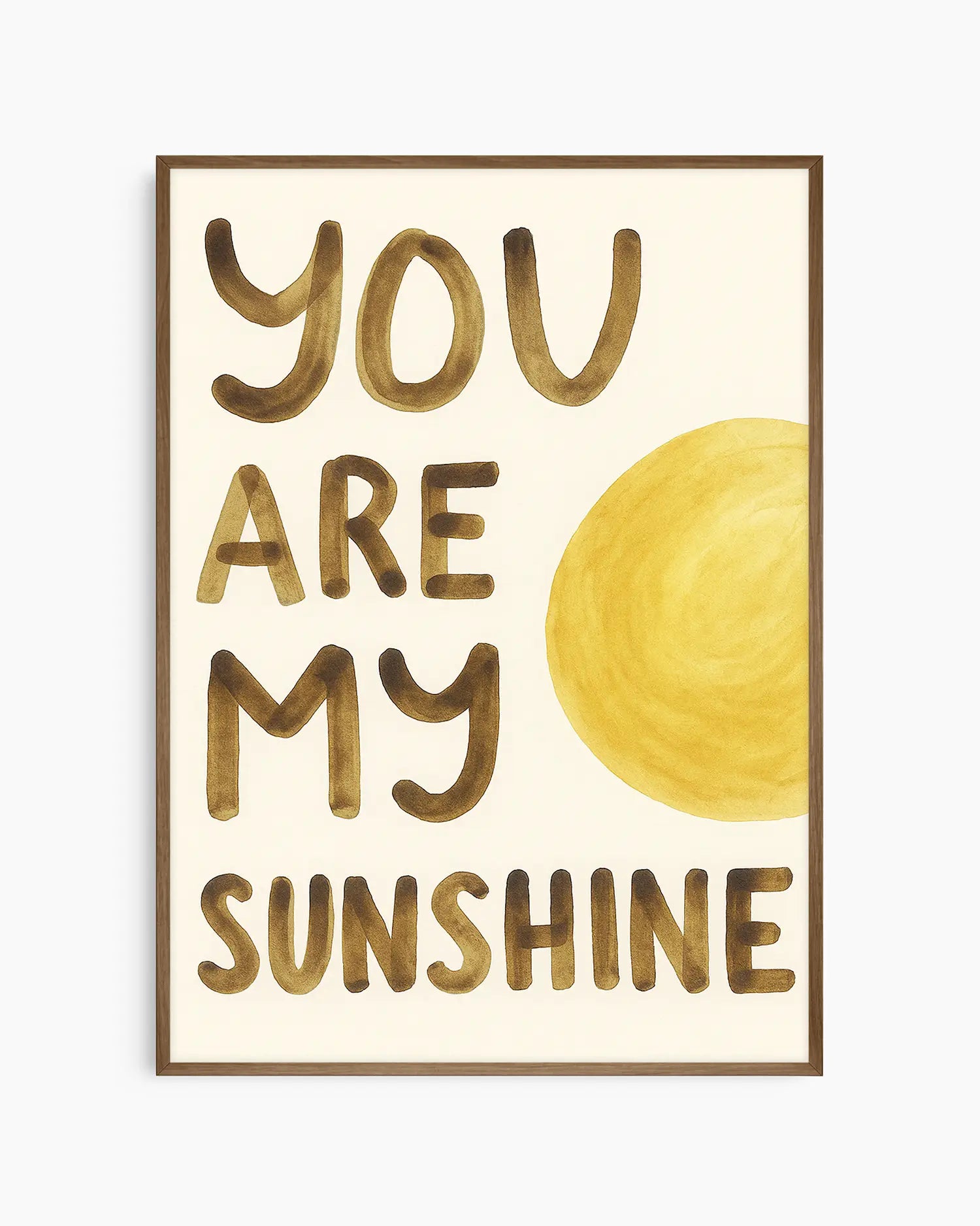 Barnrumstavla med "YOU ARE MY SUNSHINE" i gulbruna bokstäver och en rund gul sol, inramad i träram i mörk ek. En stilfull och solig detalj till barnrummet.