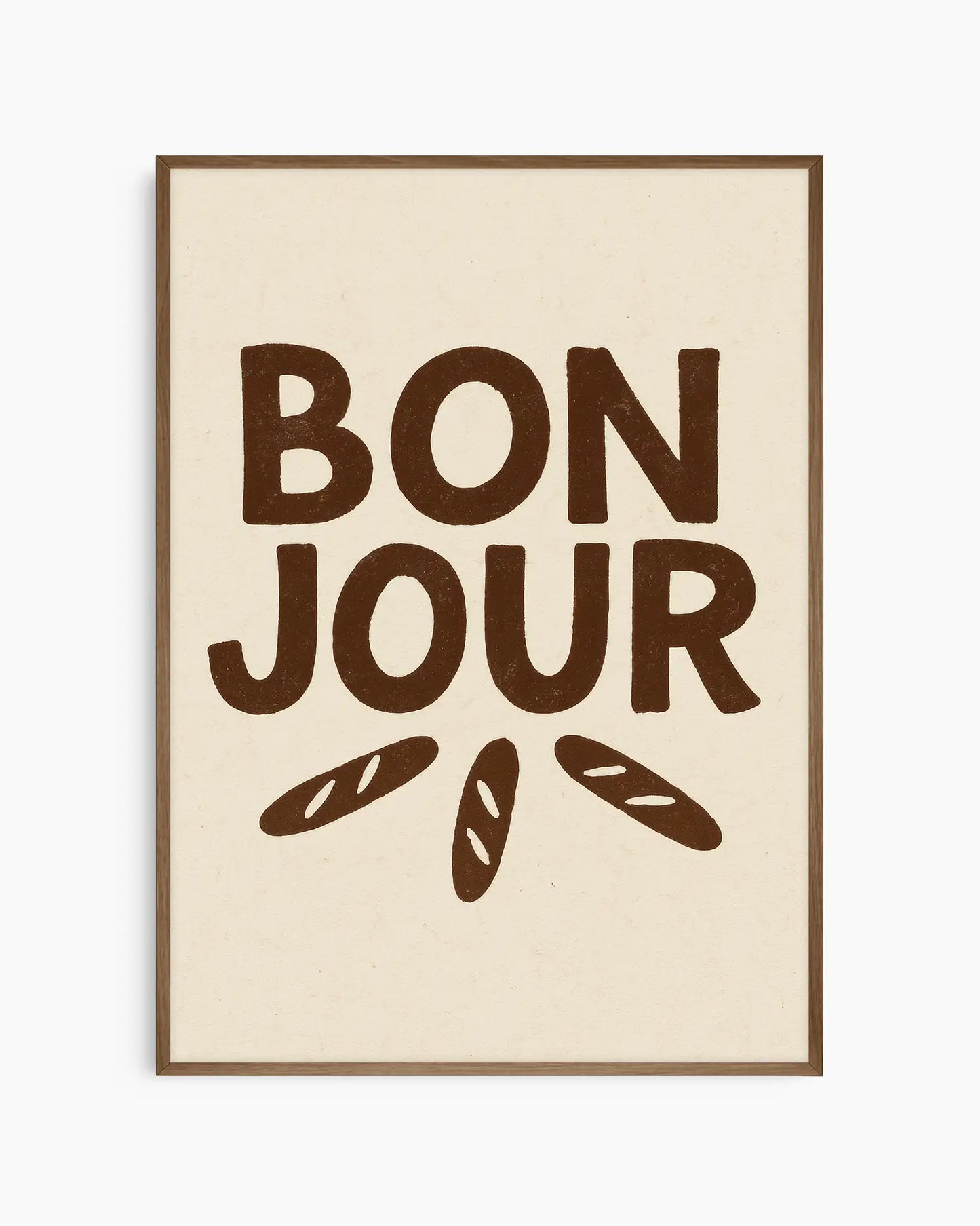 Barnrumstavla med texten "BON JOUR" i stora bruna bokstäver och små illustrerade baguetter som strålar ut under texten, inramad i träram i mörk ek. En varm och charmig detalj.