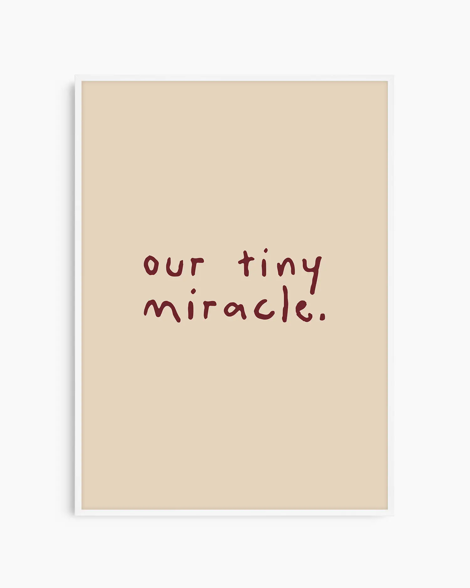 Barntavla med den vinröda texten "our tiny miracle." på beige bakgrund, inramad i vit träram. En ljus och minimalistisk dekoration med fin känsla.