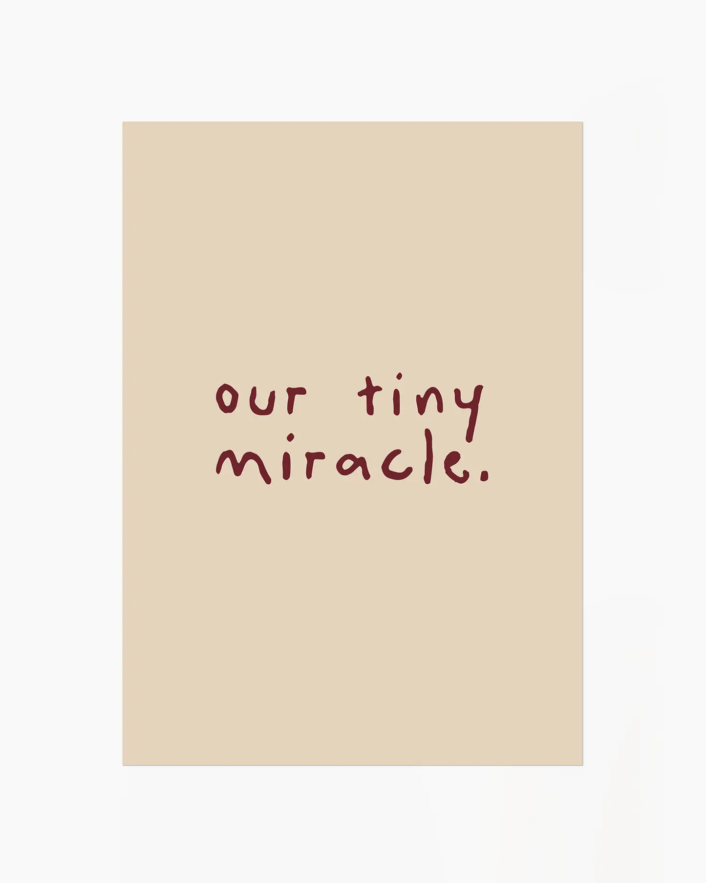 Barntavla med den vinröda handskrivna texten "our tiny miracle." på beige bakgrund. En stillsam och varm väggdekoration.