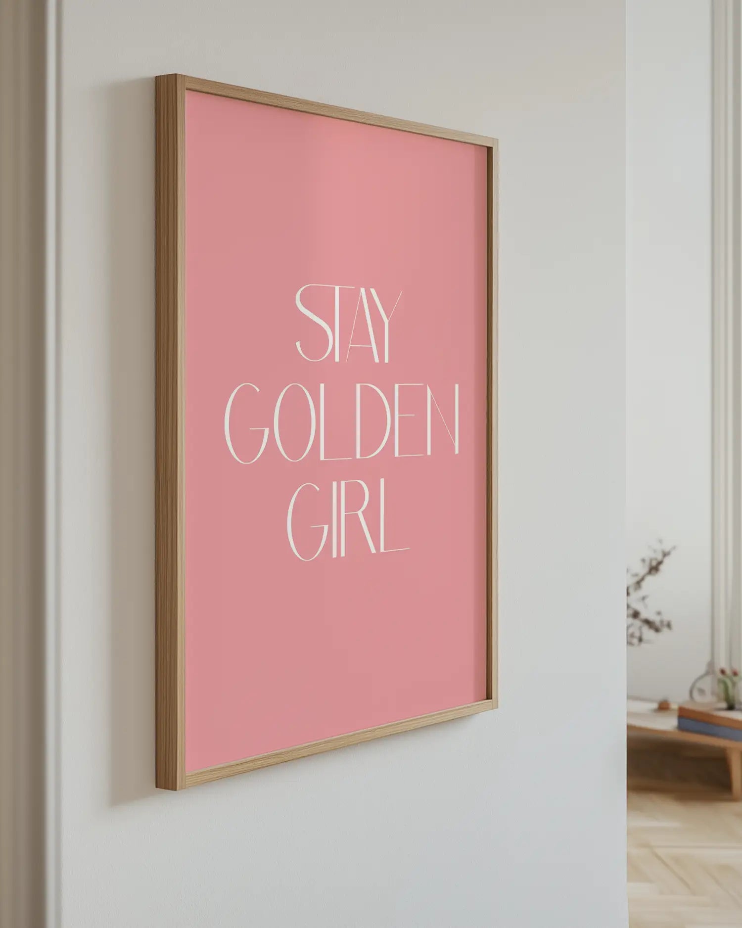 Barnrumstavla med texten “Stay Golden Girl” upphängd på vägg i ekram. En stilren och inspirerande detalj med modern design.