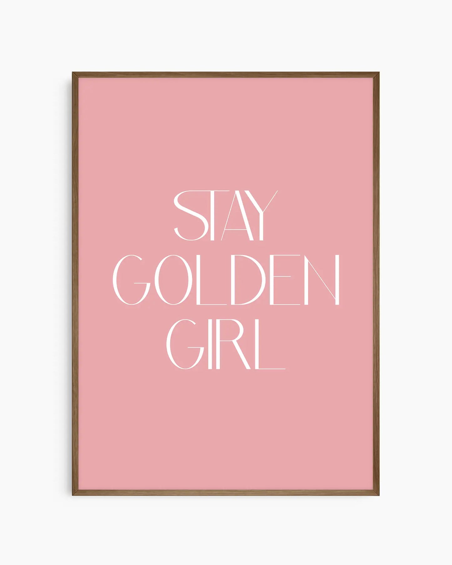 Barnrumstavla med texten “Stay Golden Girl” i vitt på rosa bakgrund, inramad i träram i mörk ek. En mjuk och elegant väggdekoration med positivt budskap.
