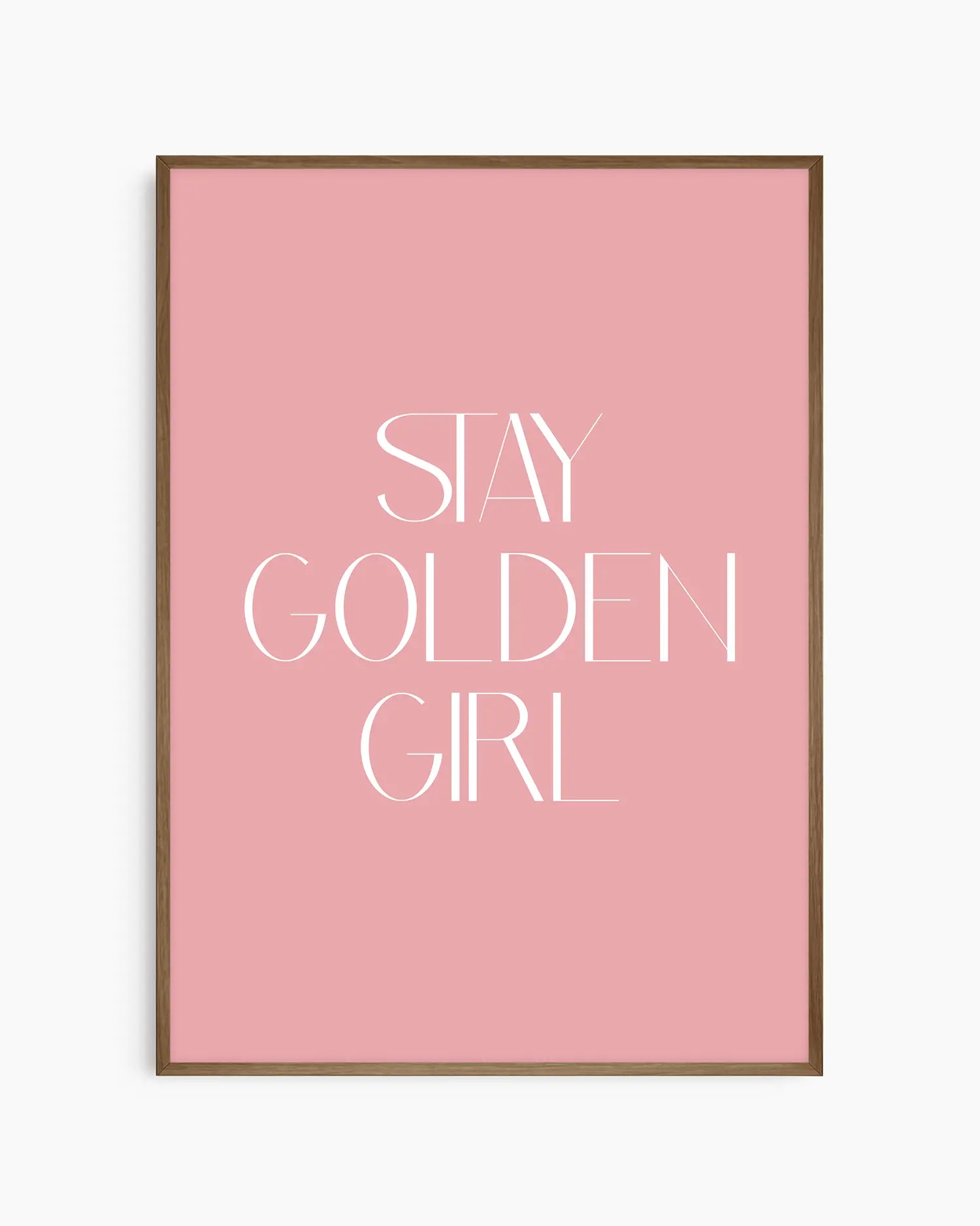 Barnrumstavla med texten “Stay Golden Girl” i vitt på rosa bakgrund, inramad i träram i mörk ek. En mjuk och elegant väggdekoration med positivt budskap.