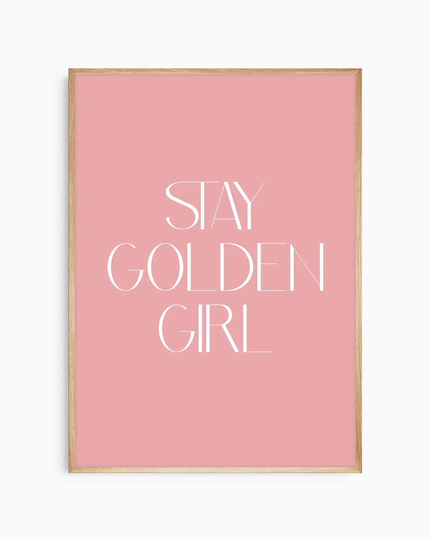 Barnrumstavla med vit text “Stay Golden Girl” på rosa bakgrund, inramad i ekram. En varm och tidlös väggdekoration med peppande budskap.