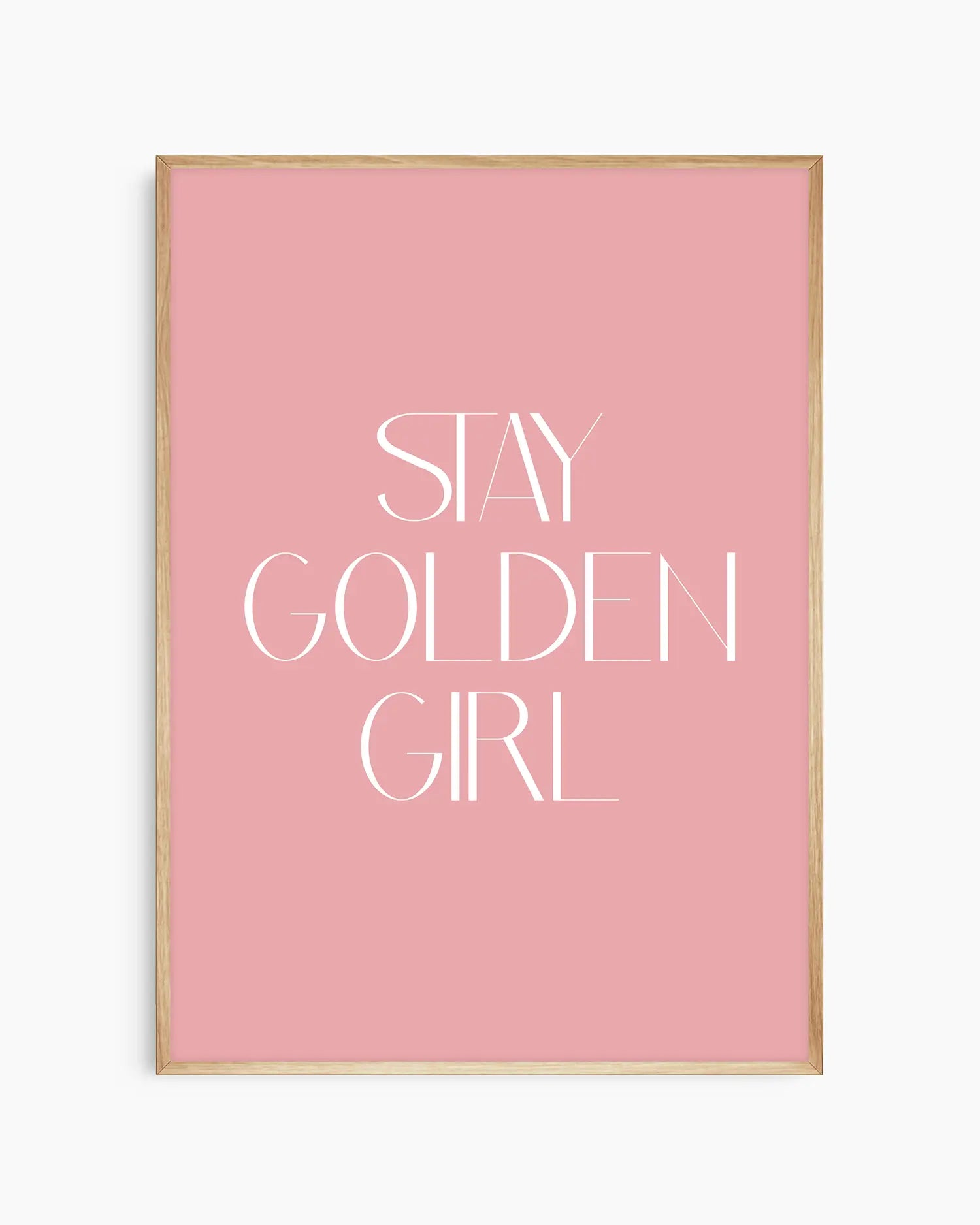 Barnrumstavla med vit text “Stay Golden Girl” på rosa bakgrund, inramad i ekram. En varm och tidlös väggdekoration med peppande budskap.
