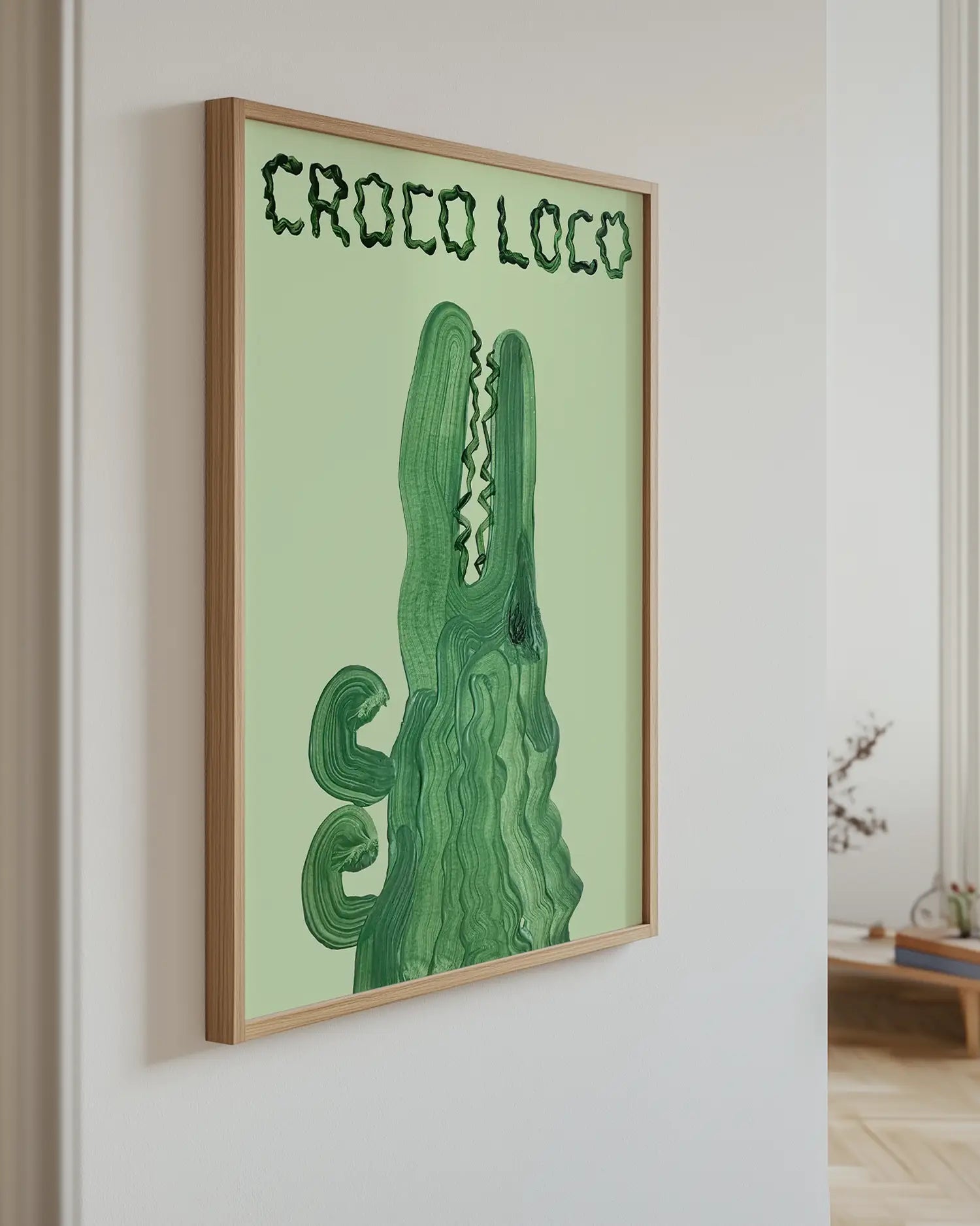 Barnrumstavla med krokodilmotiv och texten “CROCO LOCO” upphängd på vägg med ekram. En lekfull och charmig väggdekoration för barnrummet.