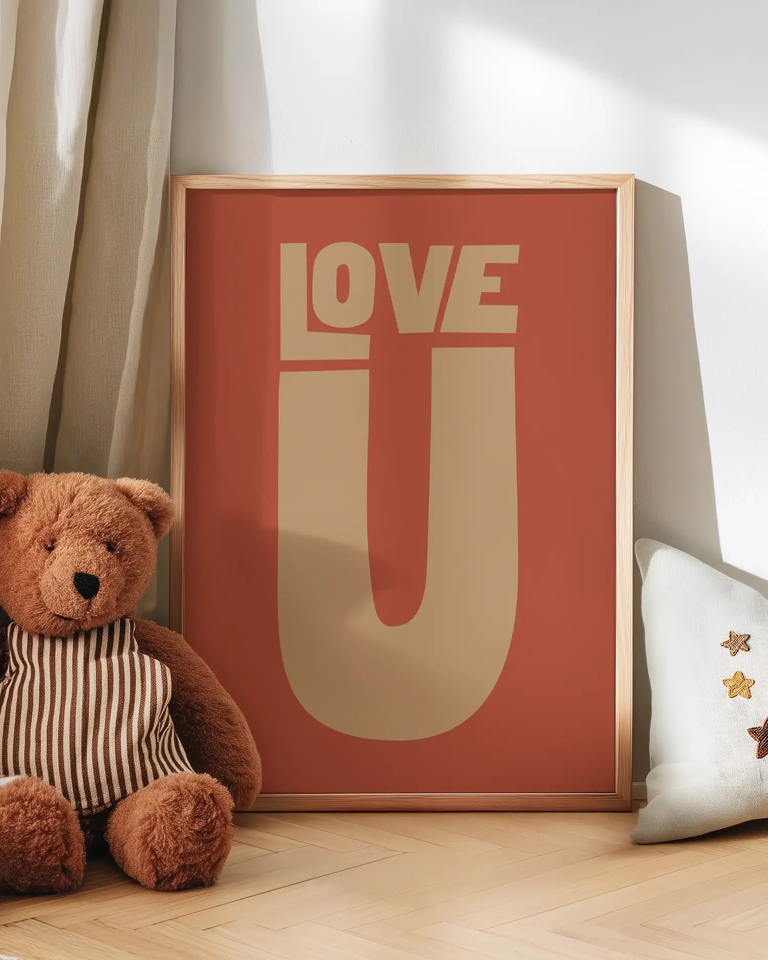 Barntavla med texten “LOVE U” i beige på terrakottafärgad bakgrund lutad mot vägg bredvid nalle. En söt och kärleksfull väggdekoration för barnrummet.