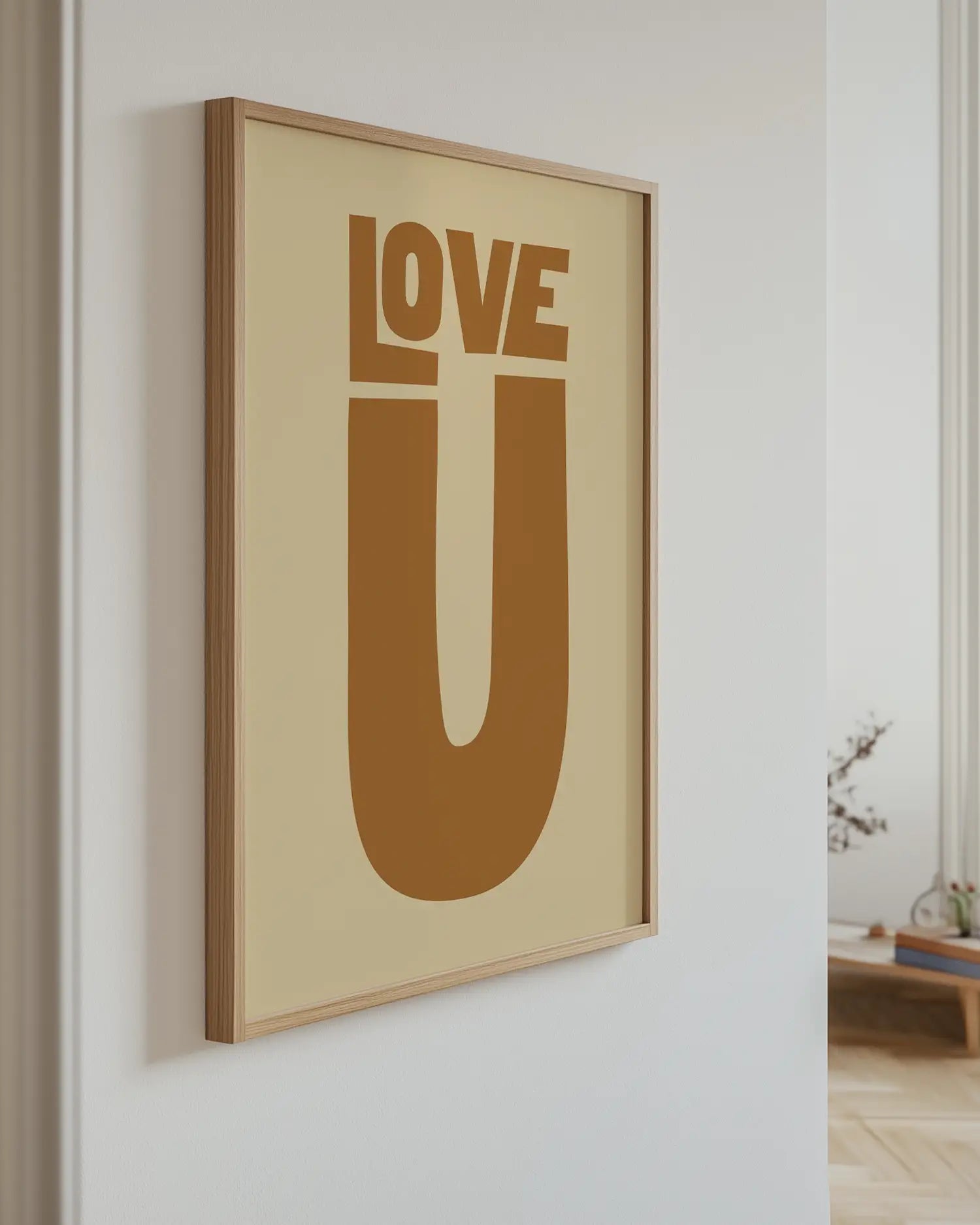Barntavla med texten “LOVE U” i brun ton upphängd på vägg med ekram. En modern och kärleksfull väggdekoration.
