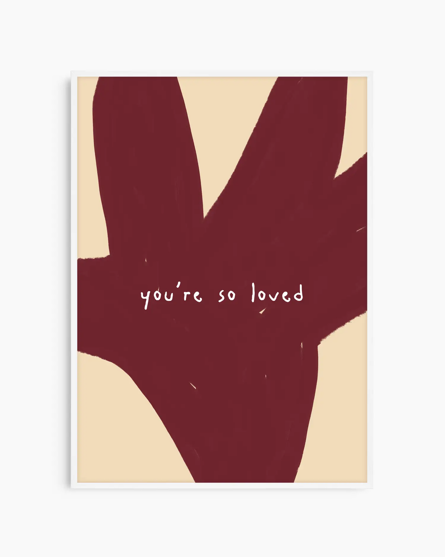 Barntavla med texten “you’re so loved” i vitt mot mörkröd bakgrundsform, inramad i vit träram. En söt och varm väggdekoration som sprider trygghet.