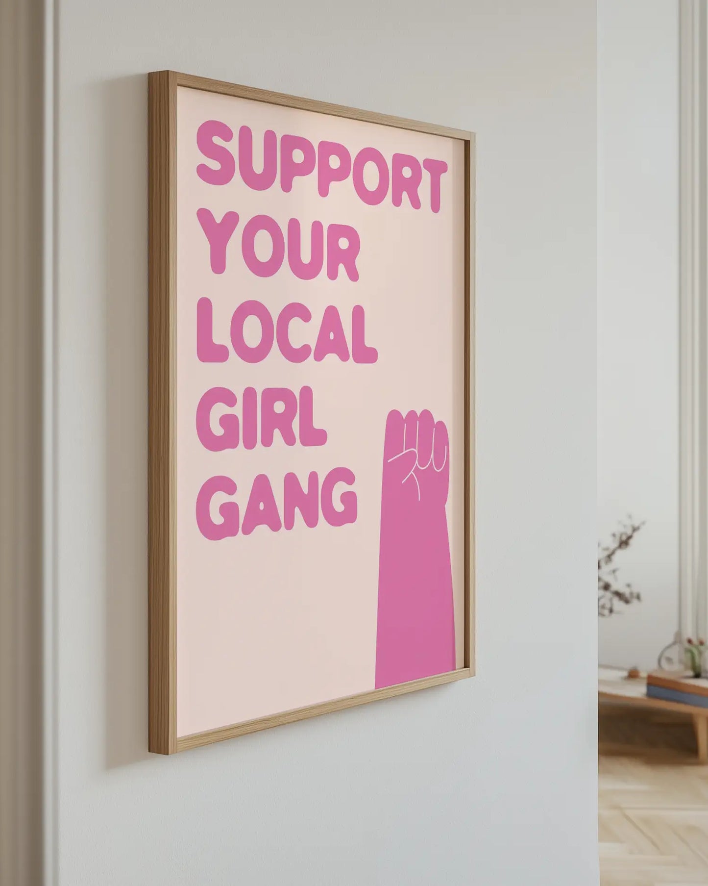Barntavla med texten “Support your local girl gang” i rosa upphängd på vägg med ekram. En lekfull och inspirerande väggdekoration.