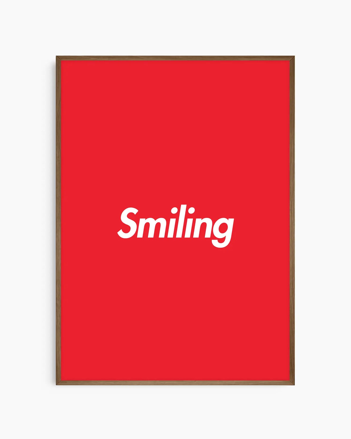 Barntavla med vit text “Smiling” på röd bakgrund, inramad i träram i mörk ek. En stilren och lekfull väggdekoration som sprider glädje.