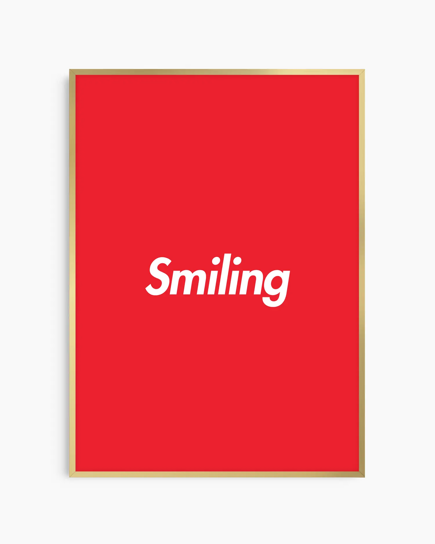 Barntavla med ordet “Smiling” i vitt på röd bakgrund, inramad i guld aluminiumram. En modern och upplyftande väggdekoration med varm ton.