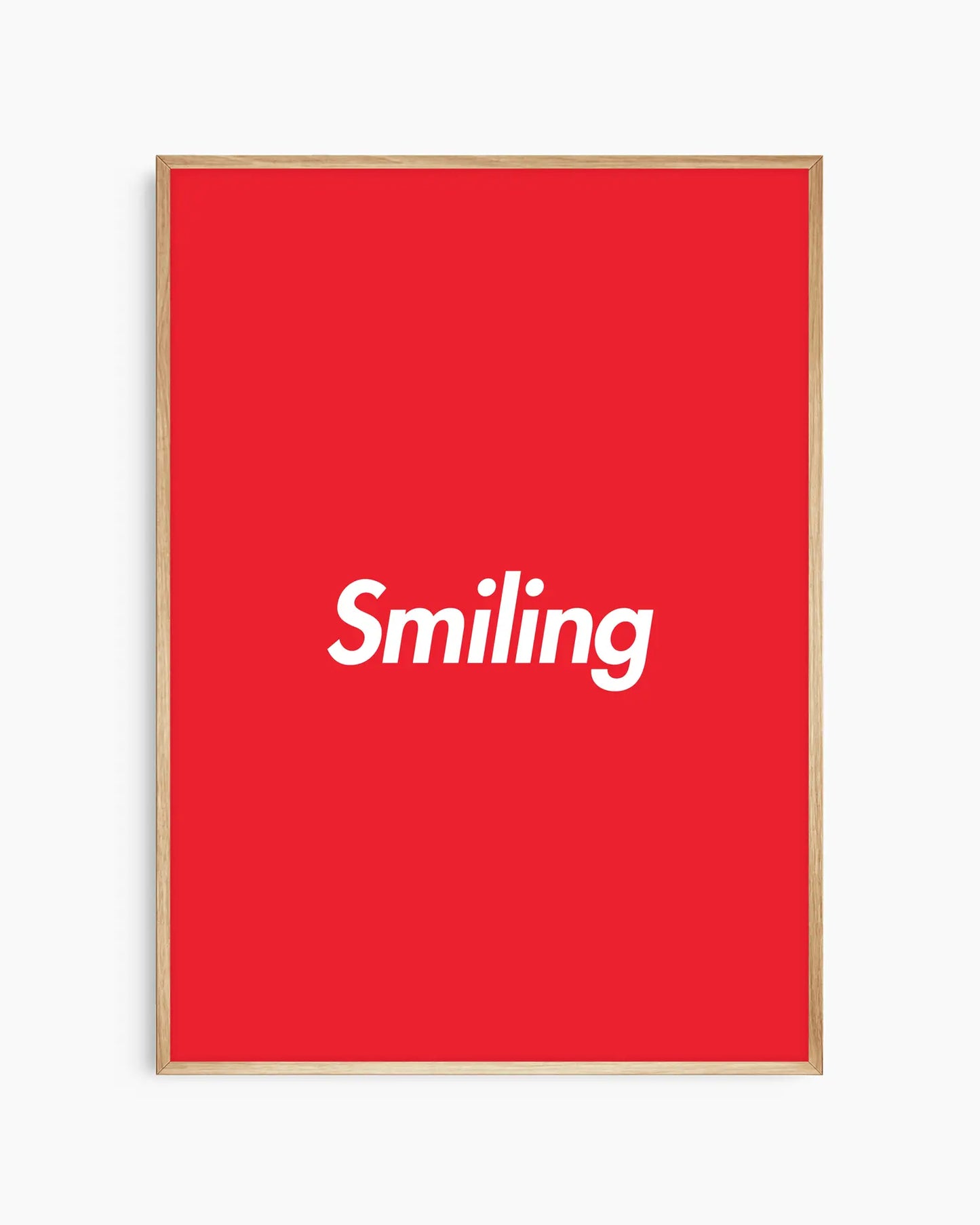 Barntavla med röd bakgrund och vit text “Smiling”, inramad i ekram. En glad och inspirerande väggdekoration som passar i barnrum.