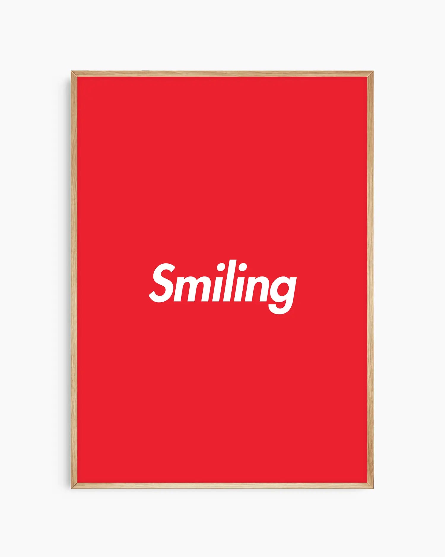 Barntavla med röd bakgrund och vit text “Smiling”, inramad i ekram. En glad och inspirerande väggdekoration som passar i barnrum.