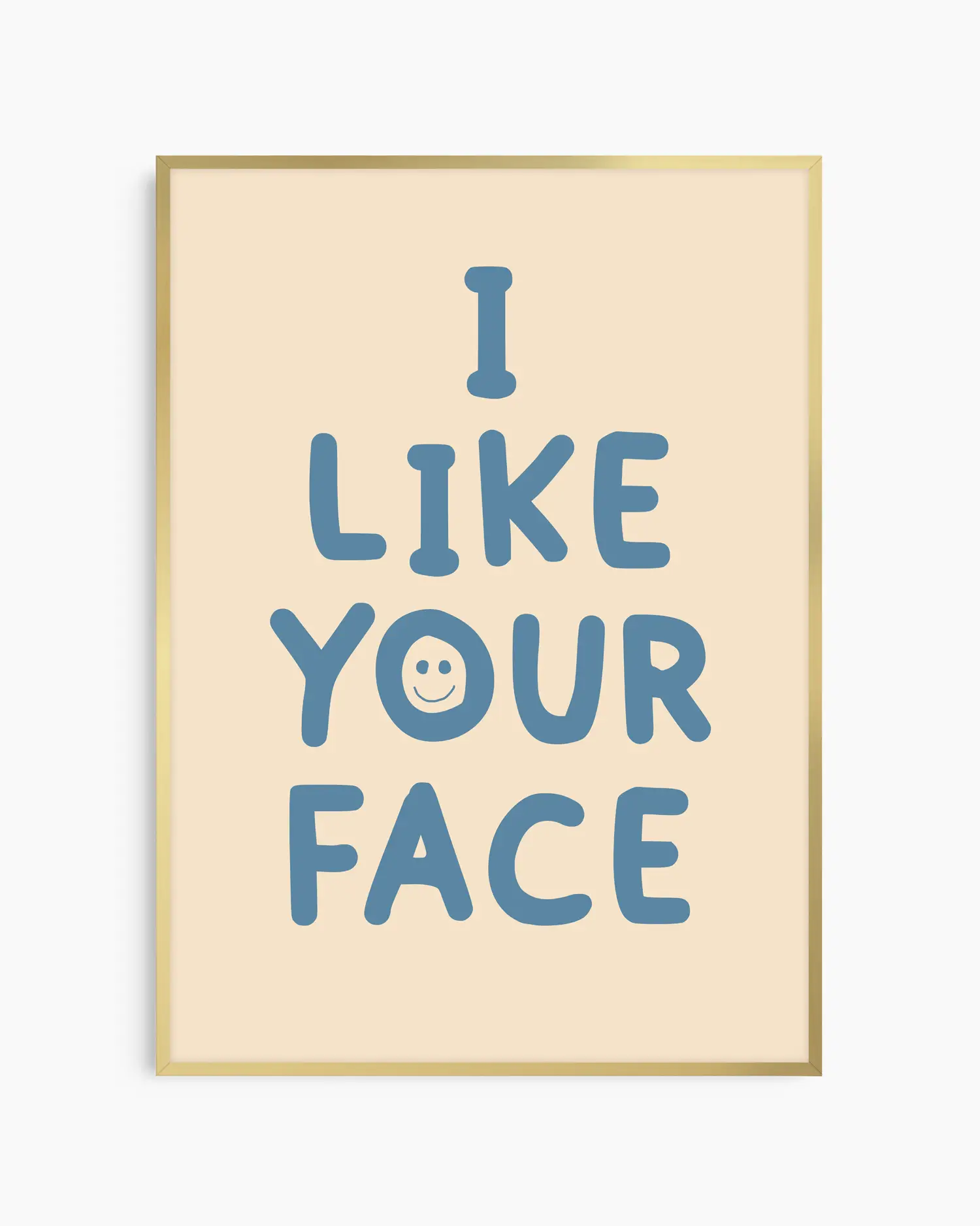 Barntavla med texten “I LIKE YOUR FACE” i blått med smiley på beige bakgrund, inramad i guld aluminiumram. En positiv och färgglad väggdekoration för barnrummet.