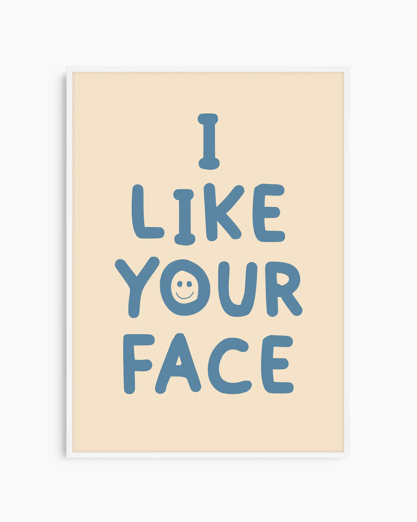 Barntavla med beige bakgrund och blå text “I LIKE YOUR FACE” med ett litet smiley-ansikte, inramad i vit träram. En lekfull och kärleksfull väggdekoration.