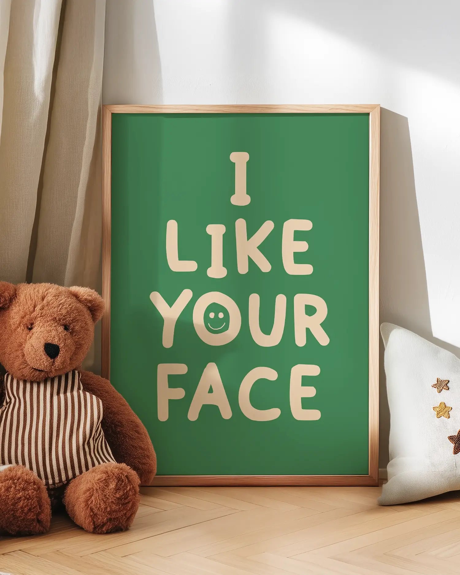Barntavla med beige text “I LIKE YOUR FACE” med smiley lutad mot vägg bredvid nalle. En söt och rolig väggdekoration som skapar en varm känsla i barnrummet.