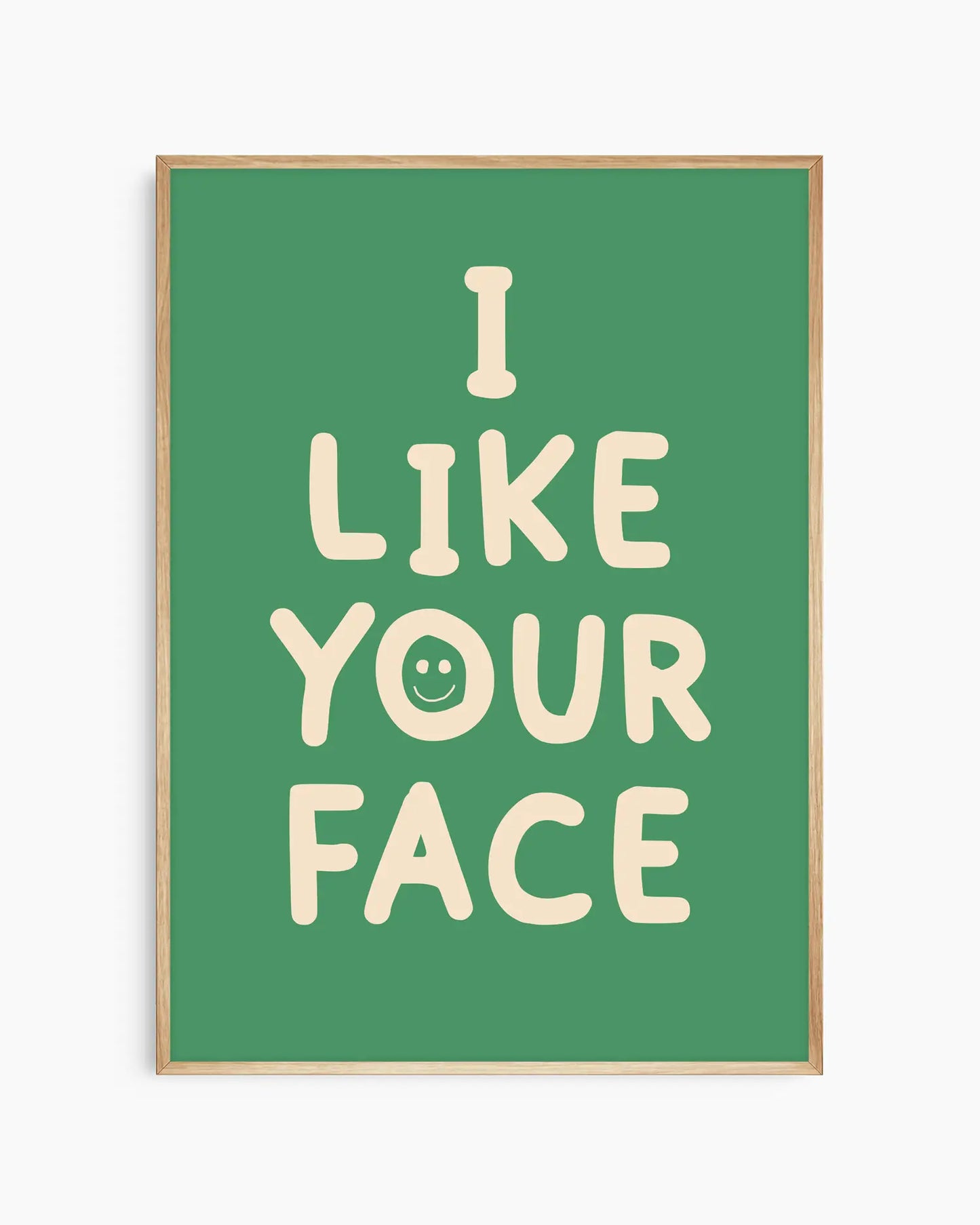 Barntavla med texten “I LIKE YOUR FACE” i ljus ton med smiley på grön bakgrund, inramad i ekram. En söt och modern väggdekoration som passar i barnrum.