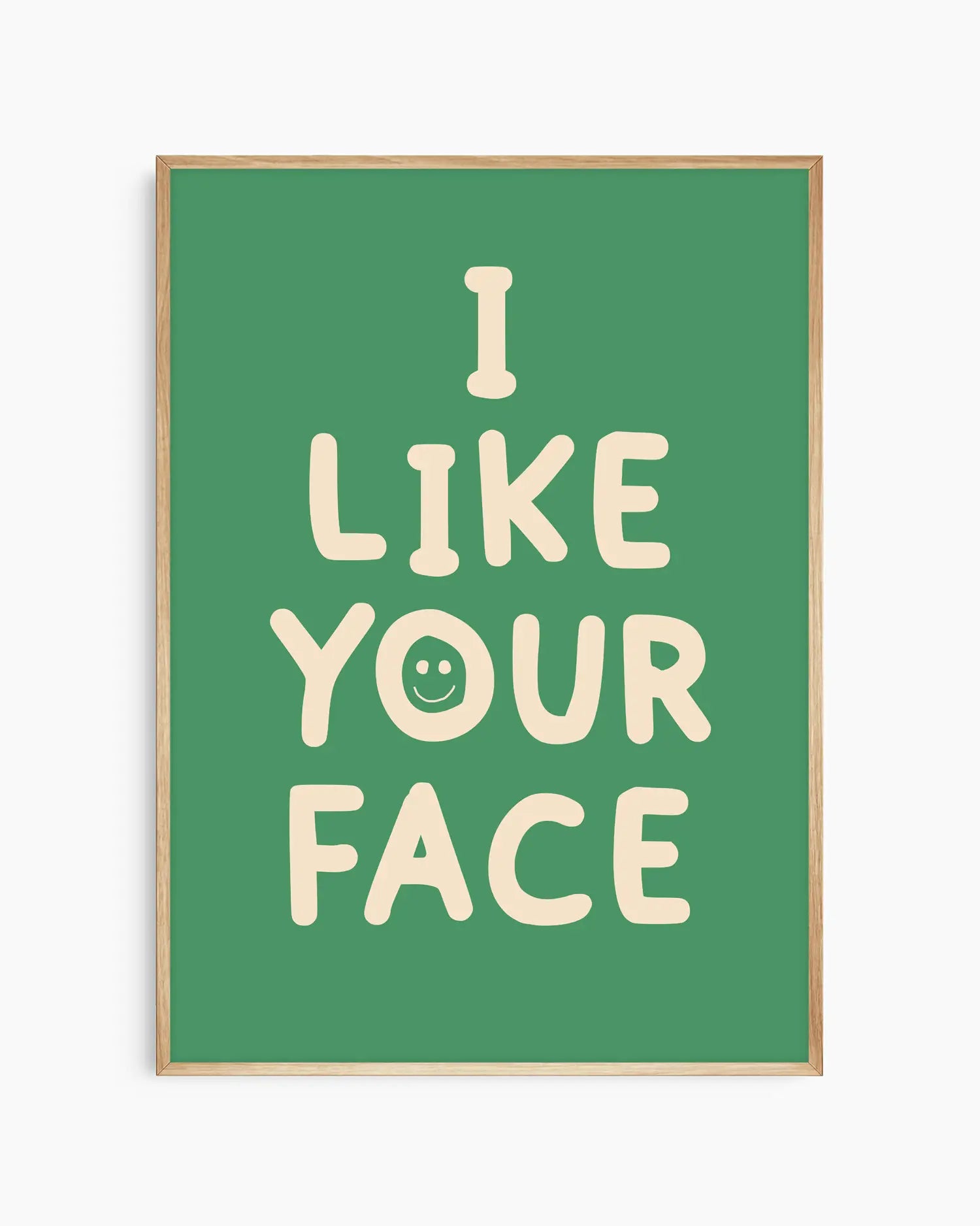 Barntavla med texten “I LIKE YOUR FACE” i ljus ton med smiley på grön bakgrund, inramad i ekram. En söt och modern väggdekoration som passar i barnrum.