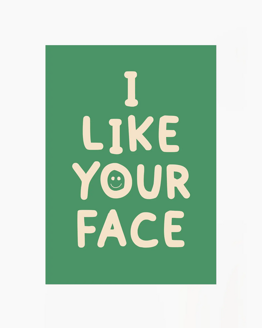 Barntavla med grön bakgrund och texten “I LIKE YOUR FACE” i beige med ett litet smiley-ansikte. En glad och charmig design som passar perfekt i barnrum.