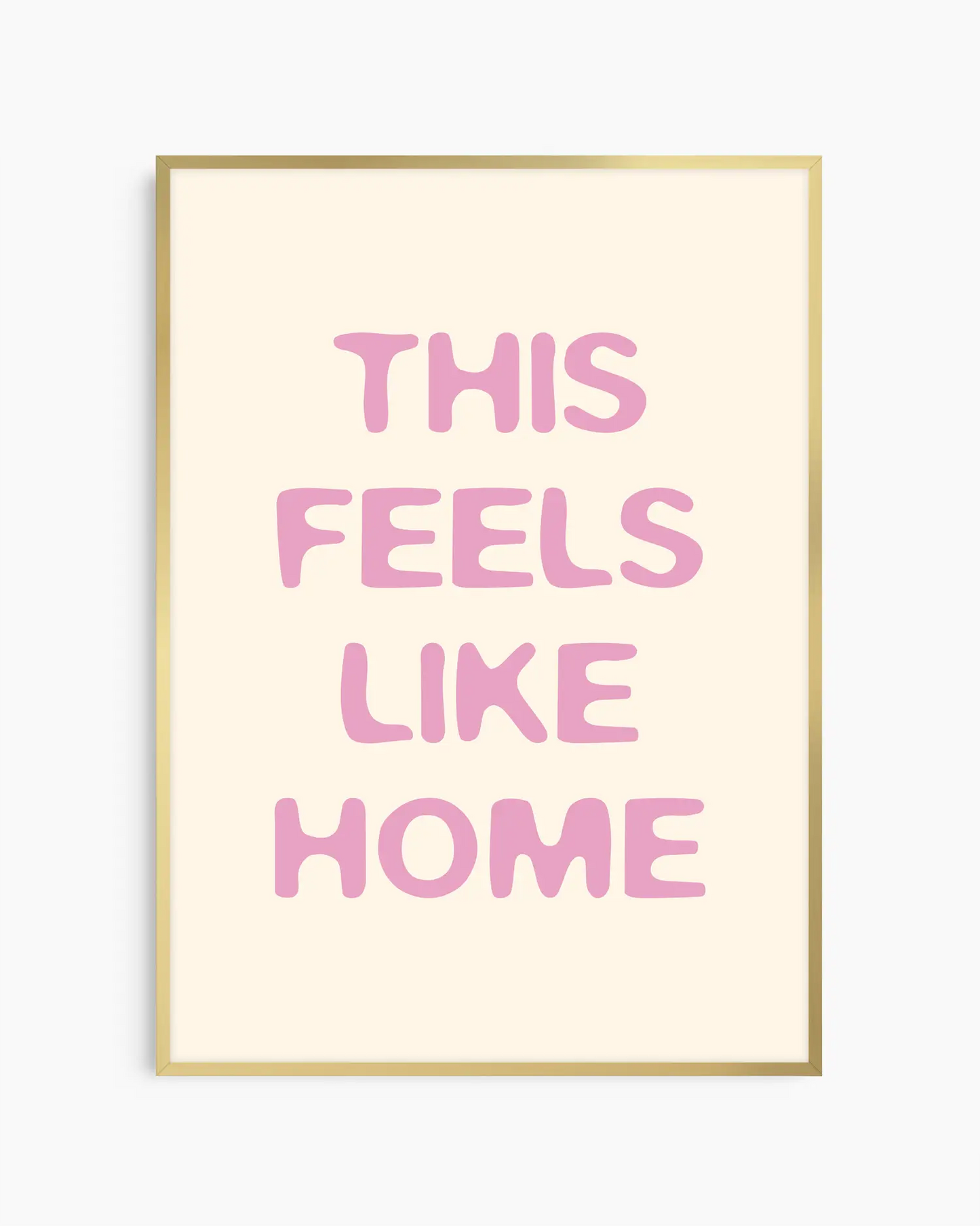 Barntavla med texten “This Feels Like Home” i rosa färg, inramad i guld aluminiumram. En stilren och varm väggdekoration som skapar en mjuk atmosfär.