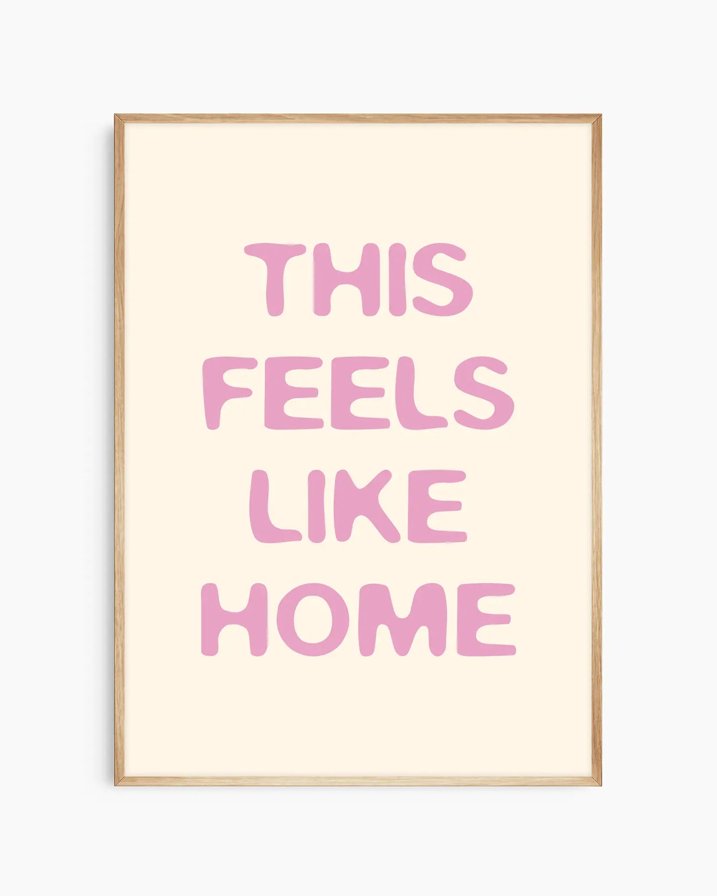 Barntavla med rosa text “This Feels Like Home” på ljus bakgrund, inramad i ekram. En naturlig och harmonisk väggdekoration som förmedlar trygghet.