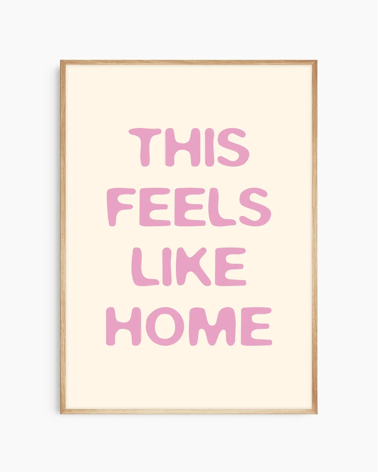 Barntavla med rosa text “This Feels Like Home” på ljus bakgrund, inramad i ekram. En naturlig och harmonisk väggdekoration som förmedlar trygghet.