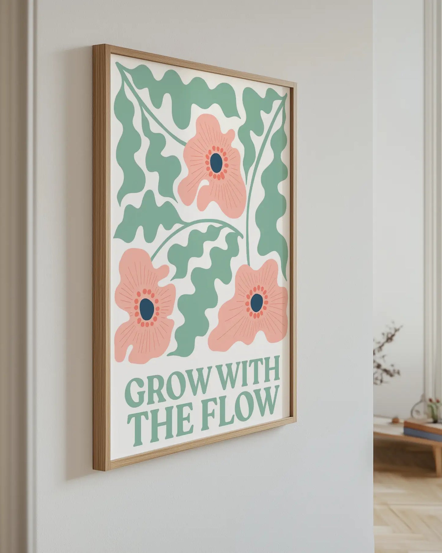 Barntavla med rosa blommor och text “Grow With The Flow” upphängd på vägg med ekram. En färgstark och harmonisk väggdekoration som lyfter rummet.