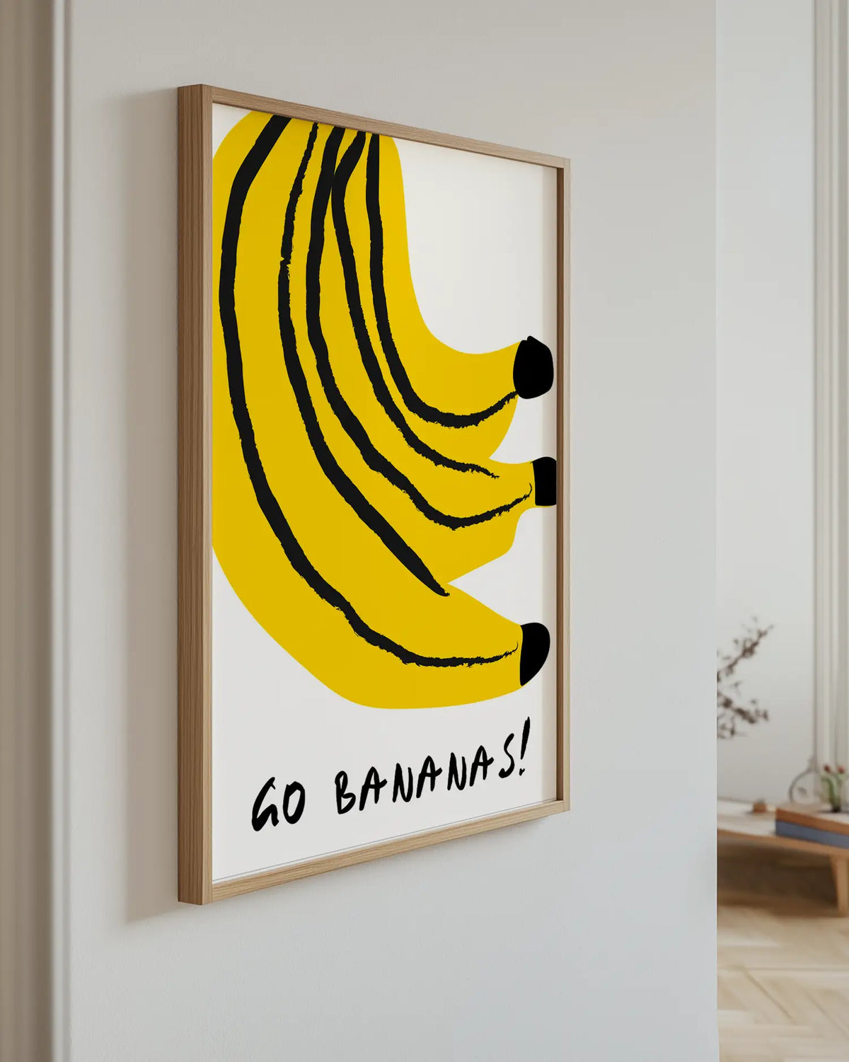 Barntavla med gula bananer och svart text upphängd på vägg med ekram. En glad och iögonfallande väggdekoration med lekfull stil.