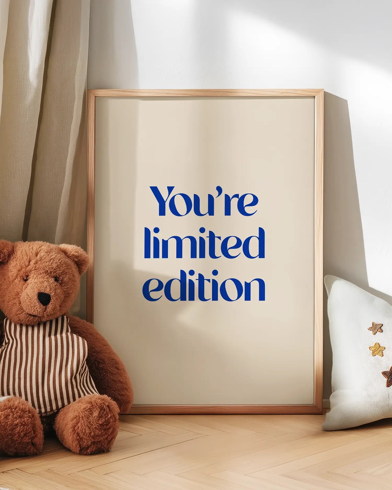 Barntavla med blå text “You’re limited edition” lutad mot vägg bredvid nalle. En varm och uppmuntrande väggdekoration som sprider positiv energi.