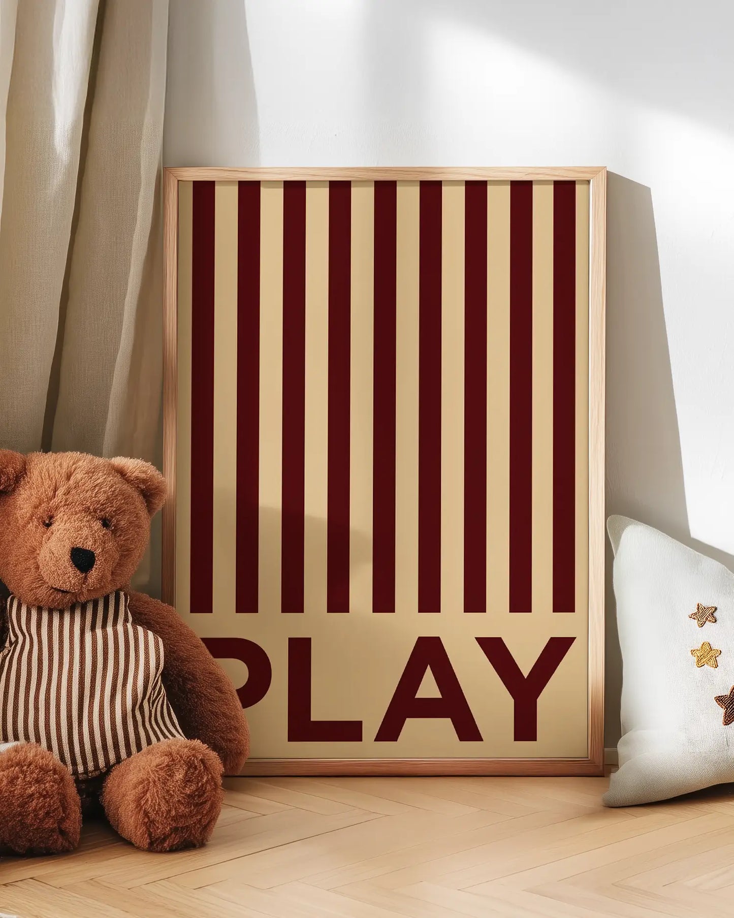 Barntavla med röda ränder och texten “PLAY” lutad mot vägg bredvid nalle. En charmig och inspirerande väggdekoration med retrostil.