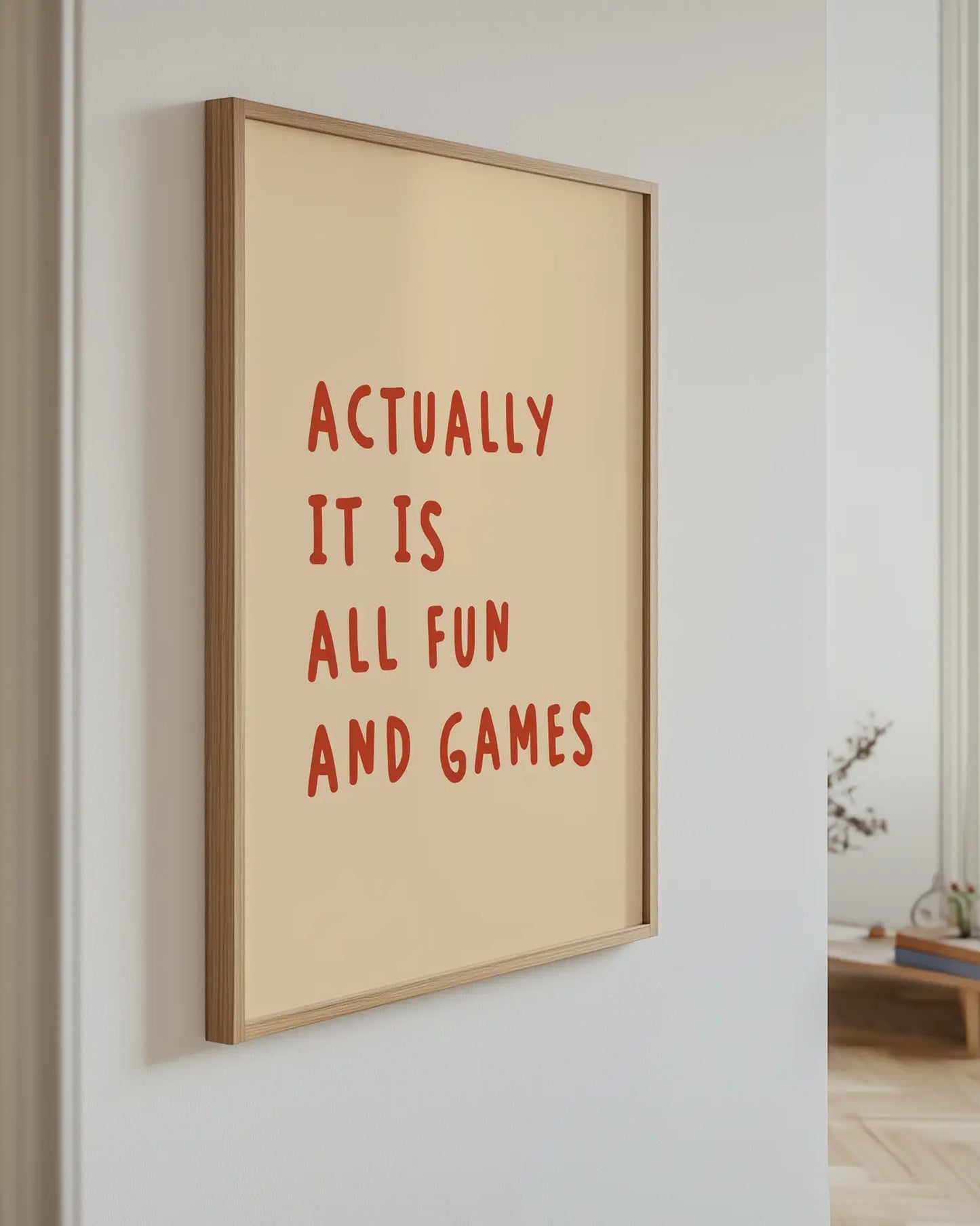 Barntavla med texten “ACTUALLY IT IS ALL FUN AND GAMES” i rostbrunt upphängd på vägg med ekram. En rolig och charmig dekoration med retrokänsla.