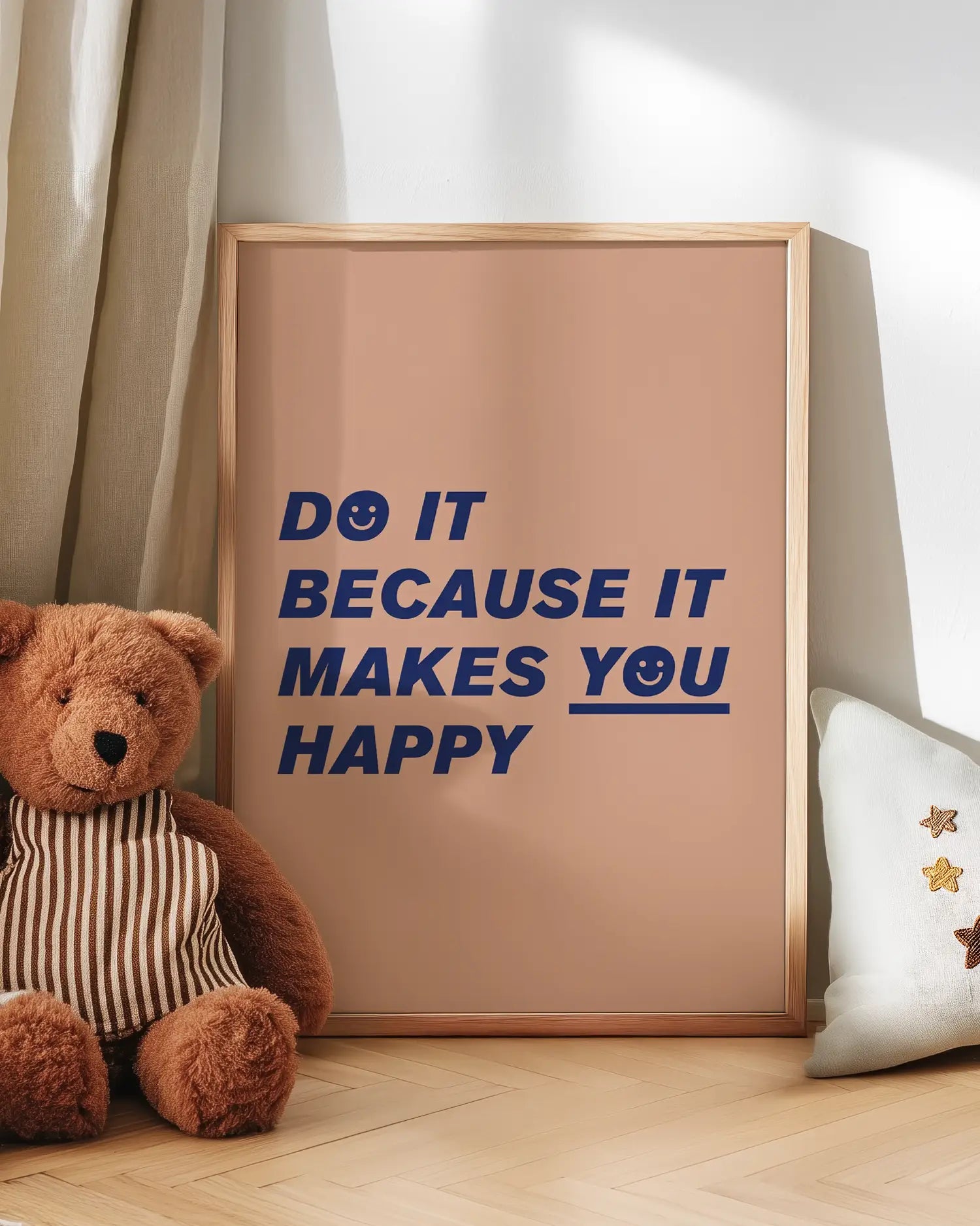 Barntavla med texten “Do it because it makes you happy” lutad mot vägg bredvid nalle. En charmig och inspirerande detalj som passar perfekt i barnrummet.
