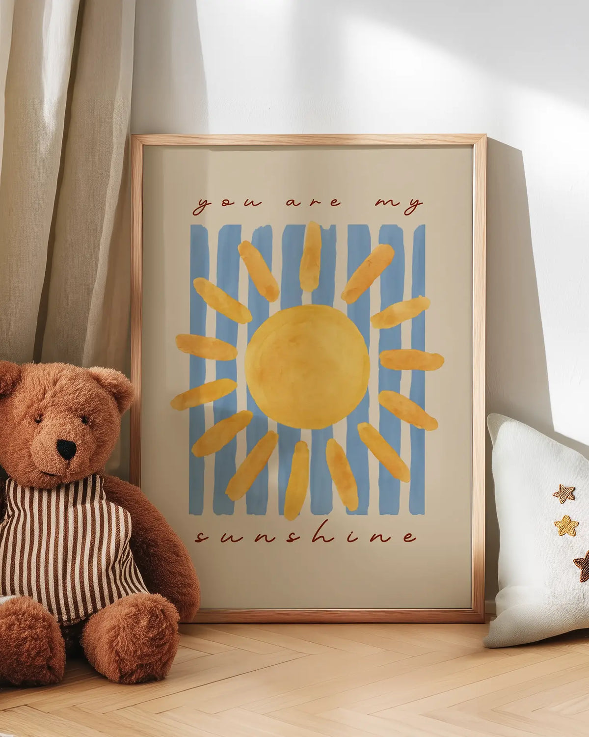 Barntavla med texten "you are my sunshine" lutad mot vägg bredvid nalle. En charmig och kärleksfull scen som skapar en varm atmosfär i barnrummet.