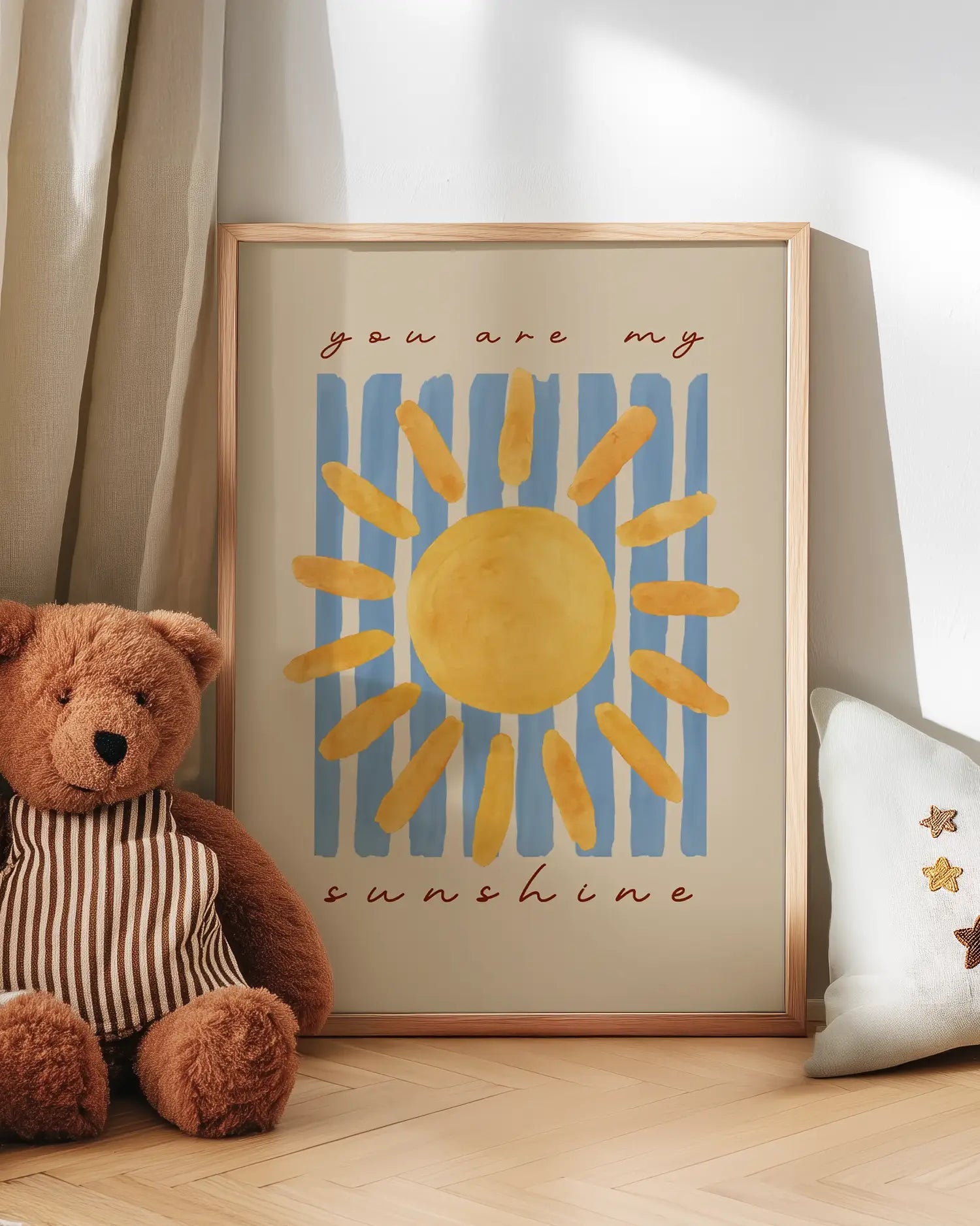 Barntavla med texten "you are my sunshine" lutad mot vägg bredvid nalle. En charmig och kärleksfull scen som skapar en varm atmosfär i barnrummet.