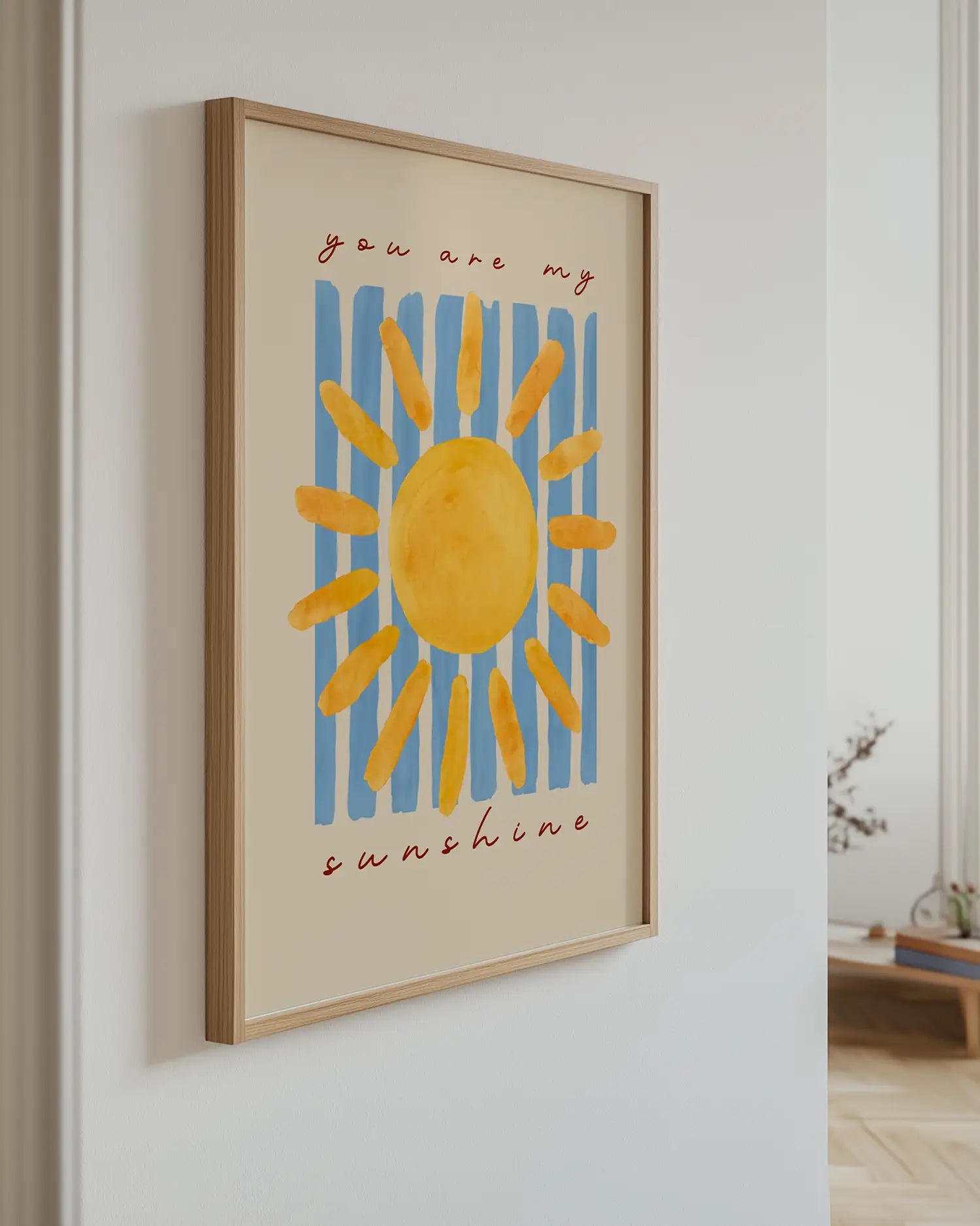 Barntavla med solmotiv och texten "you are my sunshine", upphängd på vägg med ekram. En ljus och glad väggdekoration som ger rummet liv.