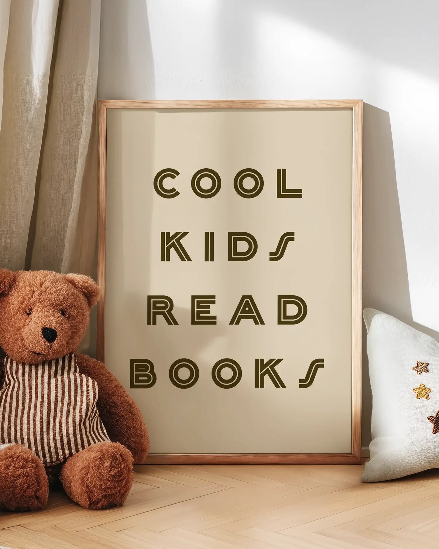 Barntavla med texten "COOL KIDS READ BOOKS" lutad mot vägg bredvid nalle. En charmig och inspirerande scen som skapar en mysig känsla i rummet.