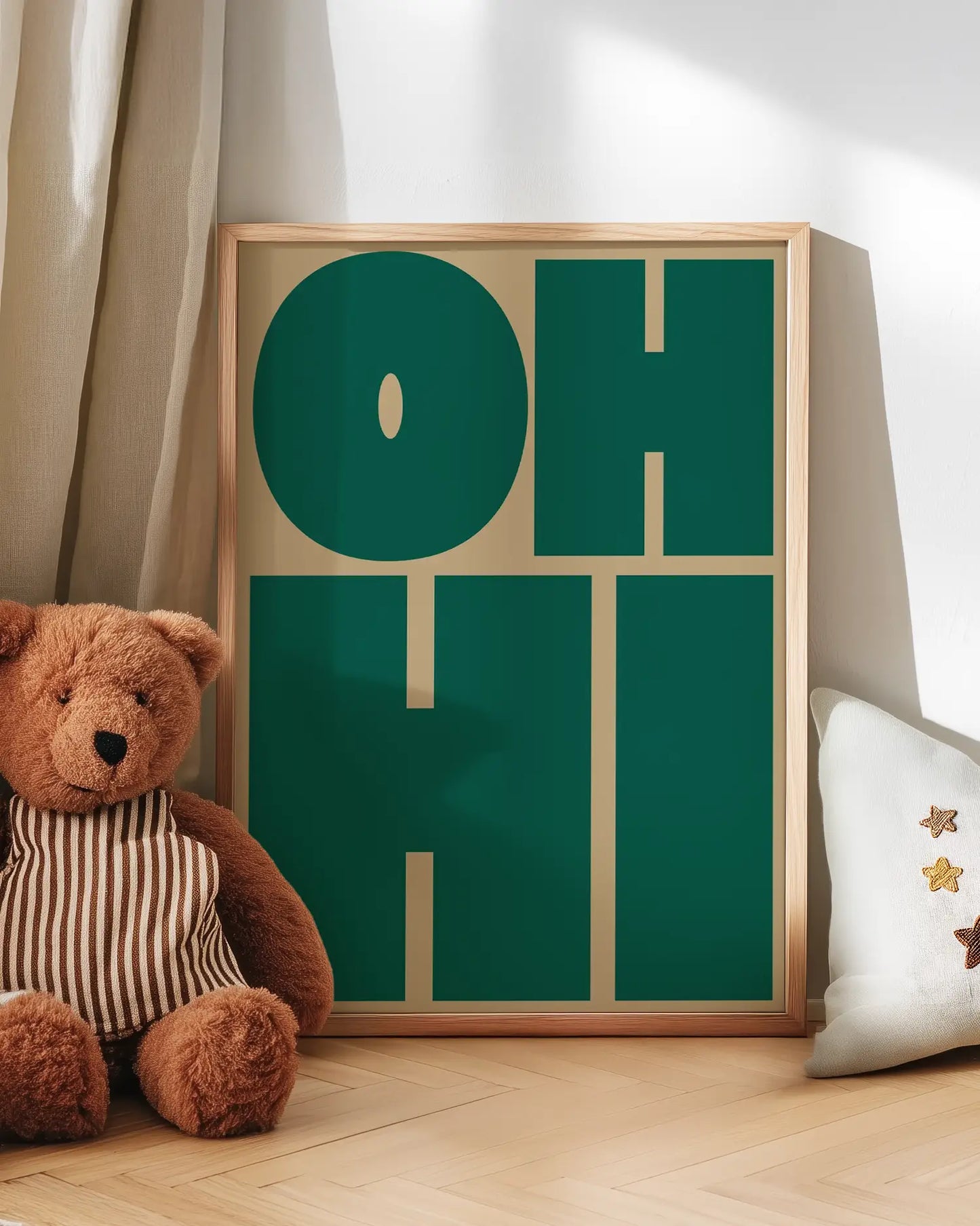 Barntavla med texten "OH HI" lutad mot vägg bredvid nalle. En söt och grafisk detalj som tillför färg och värme till rummet.