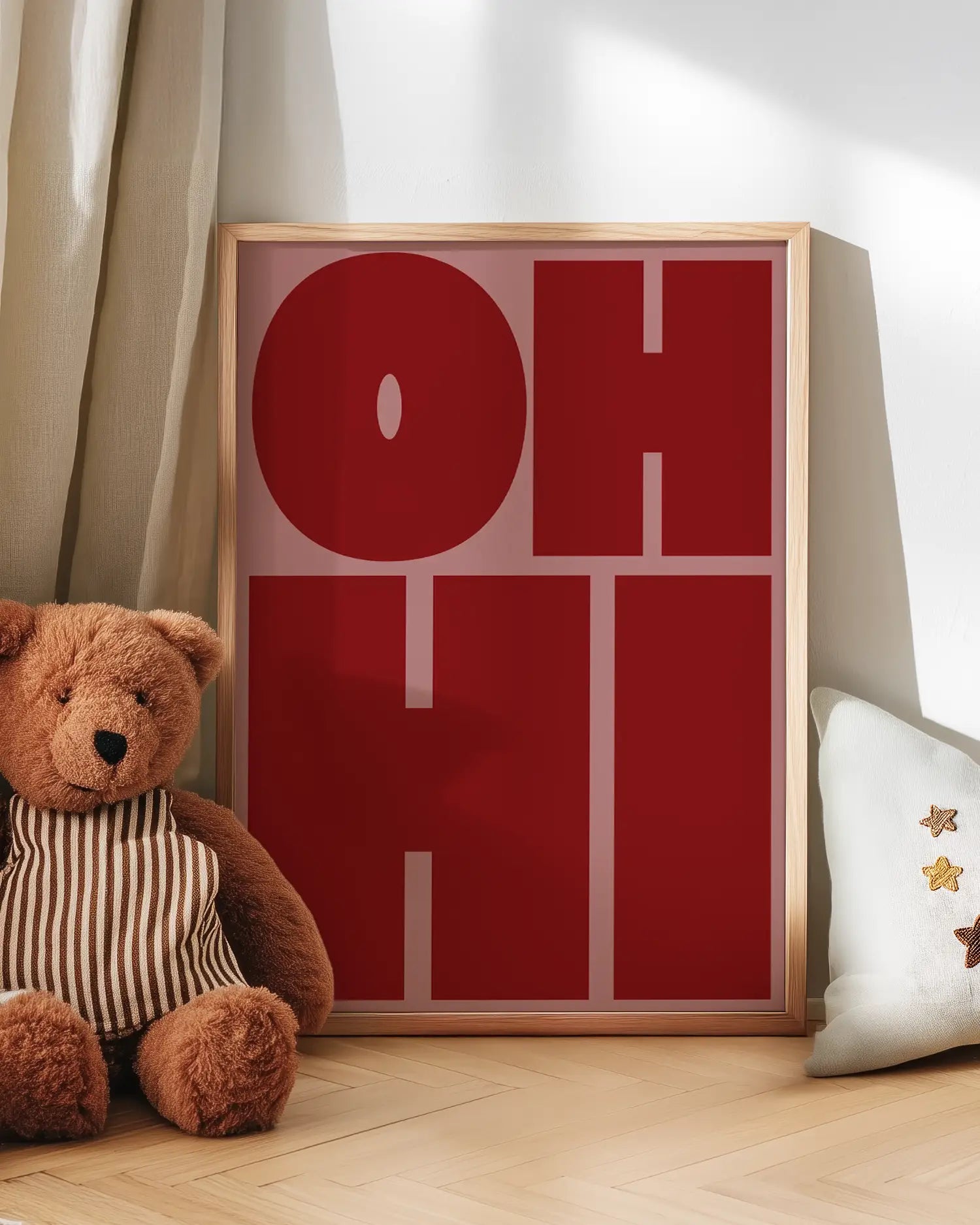 Barntavla med texten "OH HI" lutad mot vägg bredvid nalle. En charmig och färgglad scen som skapar en lekfull atmosfär i rummet.