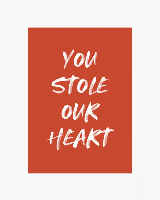 Barntavla med texten "You Stole Our Heart" i vit penselstil mot terrakotta bakgrund. En ren och känslofylld design som sprider värme.