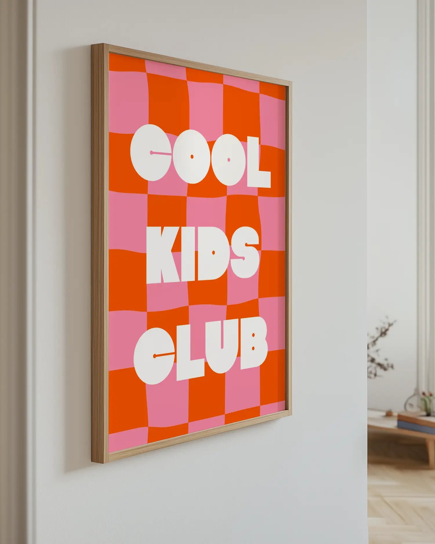 Barntavla med texten "Cool Kids Club" i vit text mot röd- och rosa rutigt mönster, upphängd på vägg med ekram. En modern och uttrycksfull detalj.