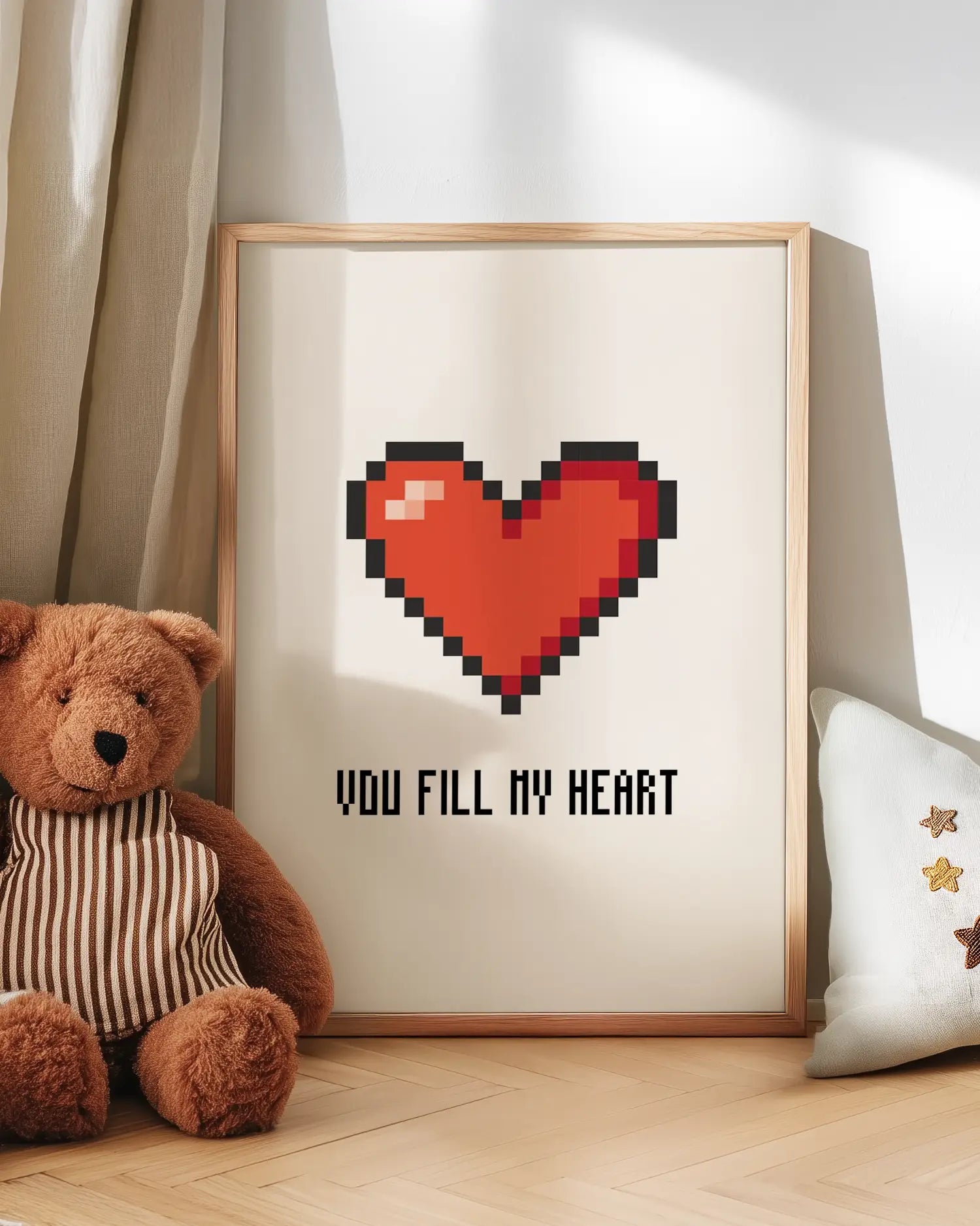 Barntavla med rött pixlat hjärta och texten "YOU FILL MY HEART", lutad mot vägg bredvid en nalle. En kärleksfull och lekfull scen för barnrummet.