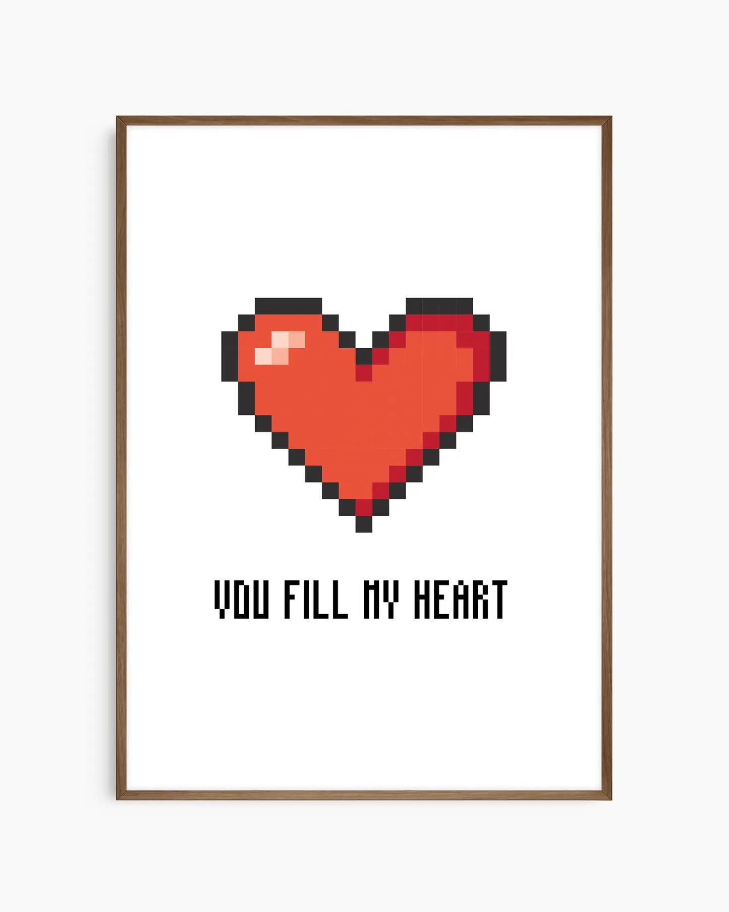 Barntavla med rött pixlat hjärta och texten "YOU FILL MY HEART" i svart, mot vit bakgrund, inramad i mörk träram. En varm och stilren tavla med spelinspirerad design.