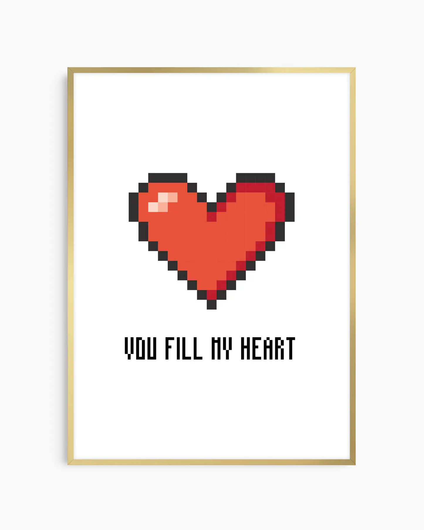 Barntavla med pixlat rött hjärta och texten "YOU FILL MY HEART" mot vit bakgrund, inramad i guld aluminiumram. En modern och lekfull väggdekoration med retrokänsla.