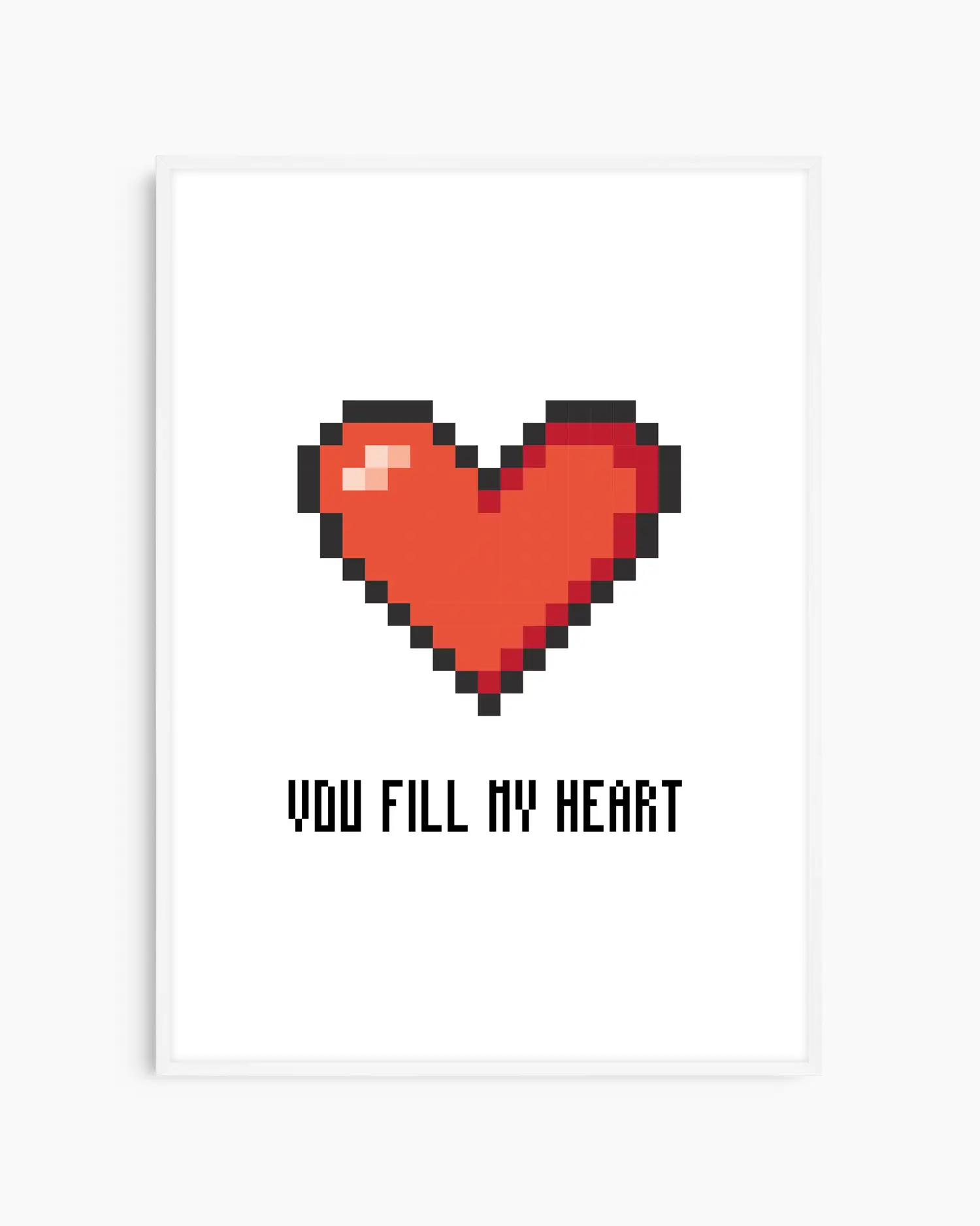 Barntavla med pixlat rött hjärta och svart text "YOU FILL MY HEART" mot vit bakgrund, inramad i vit träram. En ljus och kärleksfull detalj som passar barnrum och lekrum.