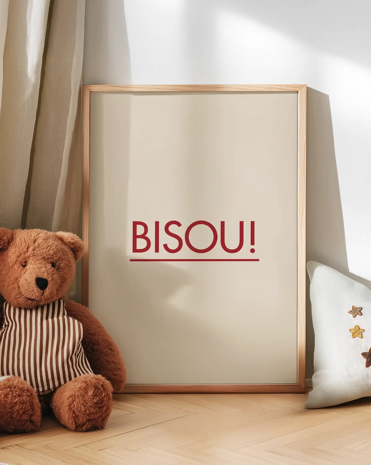 Barntavla med texten "BISOU!" i rött, lutad mot vägg bredvid en mjuk nalle. En varm och charmig scen som tillför kärlek och lekfullhet i barnrummet.